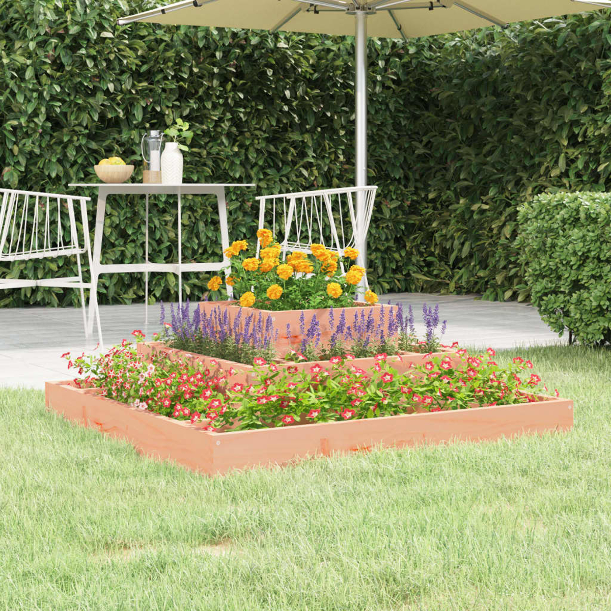 Mehrstufiger Holzblumentopf mit Blumen. Im Hintergrund ein Tisch, ein Schirm und eine grüne Hecke.