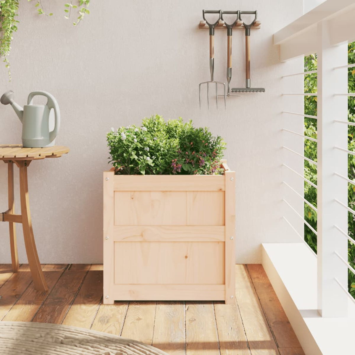 Heller Holzpflanzkasten mit grünen Pflanzen, neben einem Tisch und einem Geländer.