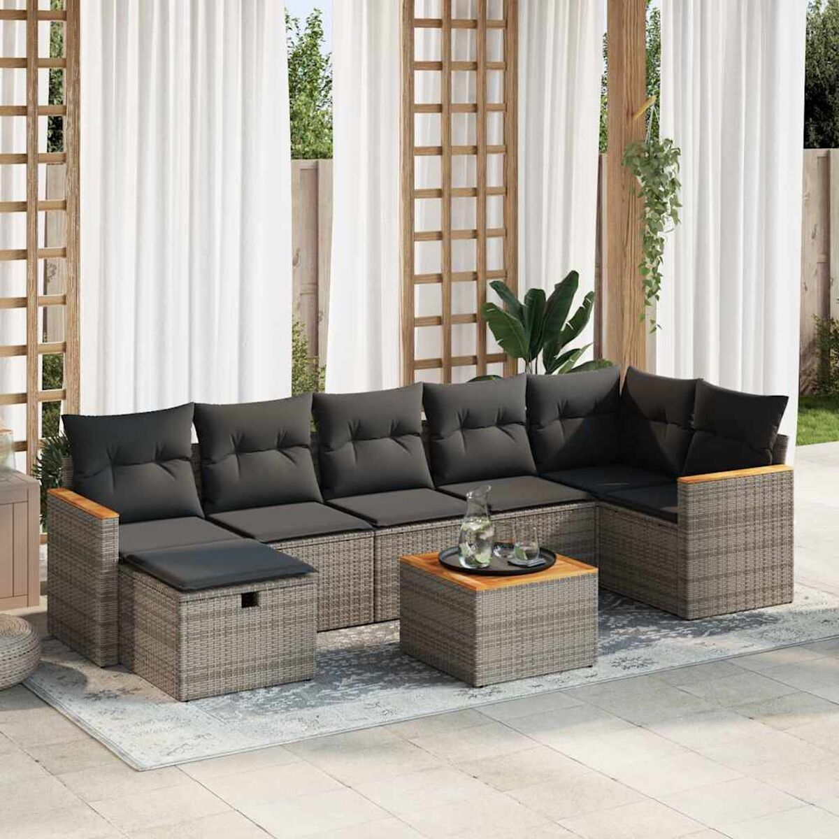 Graues Ecksofa für den Außenbereich mit einem Tisch auf einem Teppich.