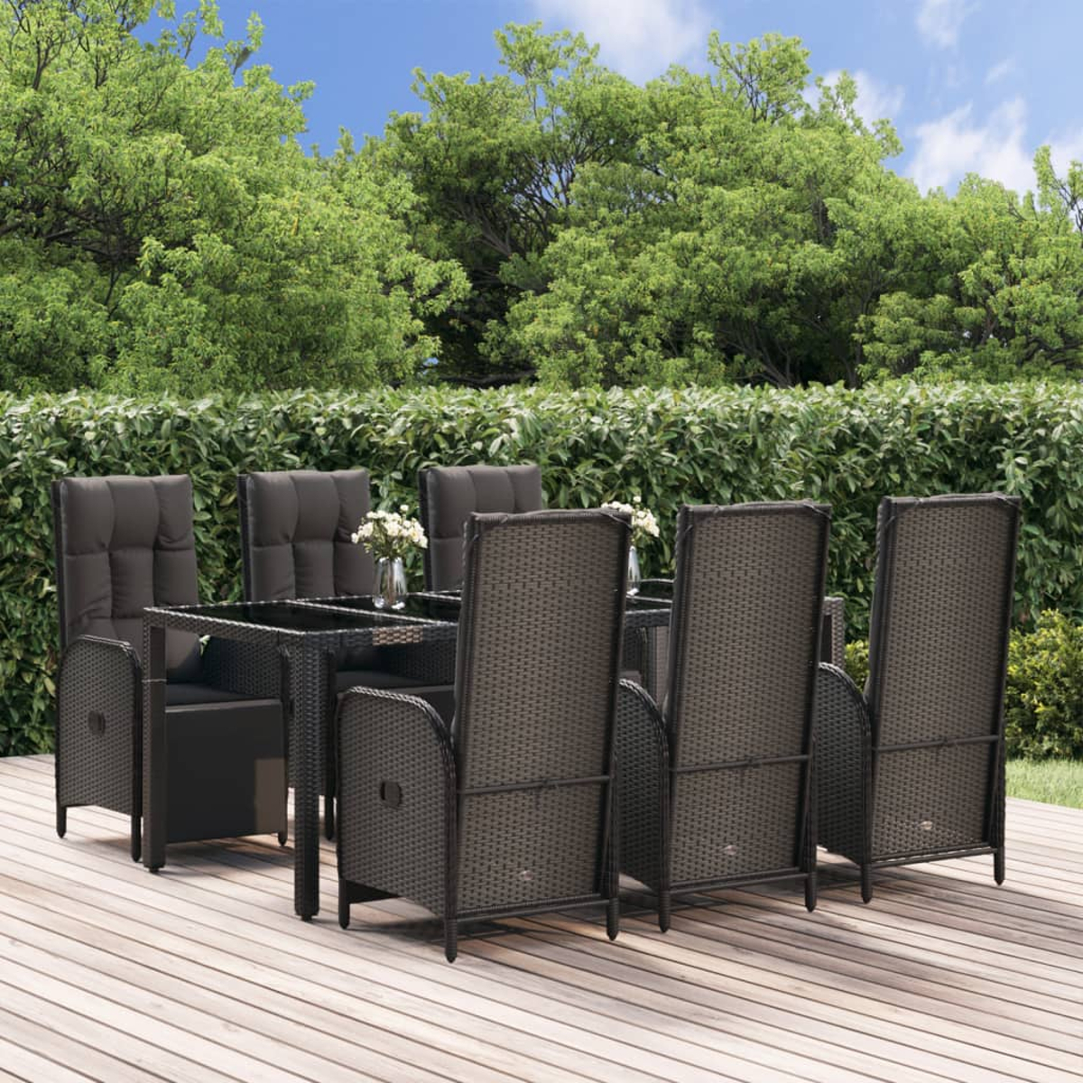 Dunkles Ess-Set aus Korbgeflecht für den Außenbereich mit Stühlen und Tisch auf Holzdeck, Gartenhintergrund.