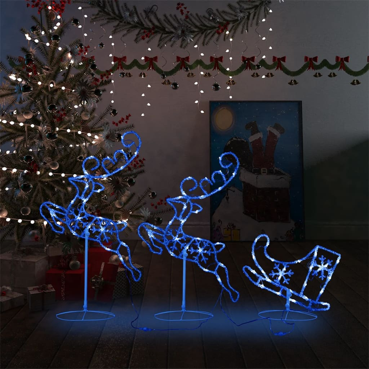 Drei beleuchtete Rentierdekorationen und ein Schlitten sowie ein Gemälde vom Weihnachtsmann.