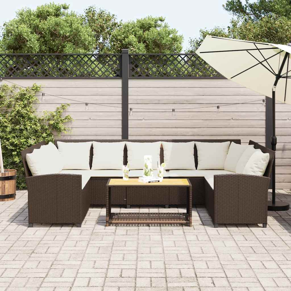 Sofá seccional exterior en un patio con mesa, sombrilla y valla.