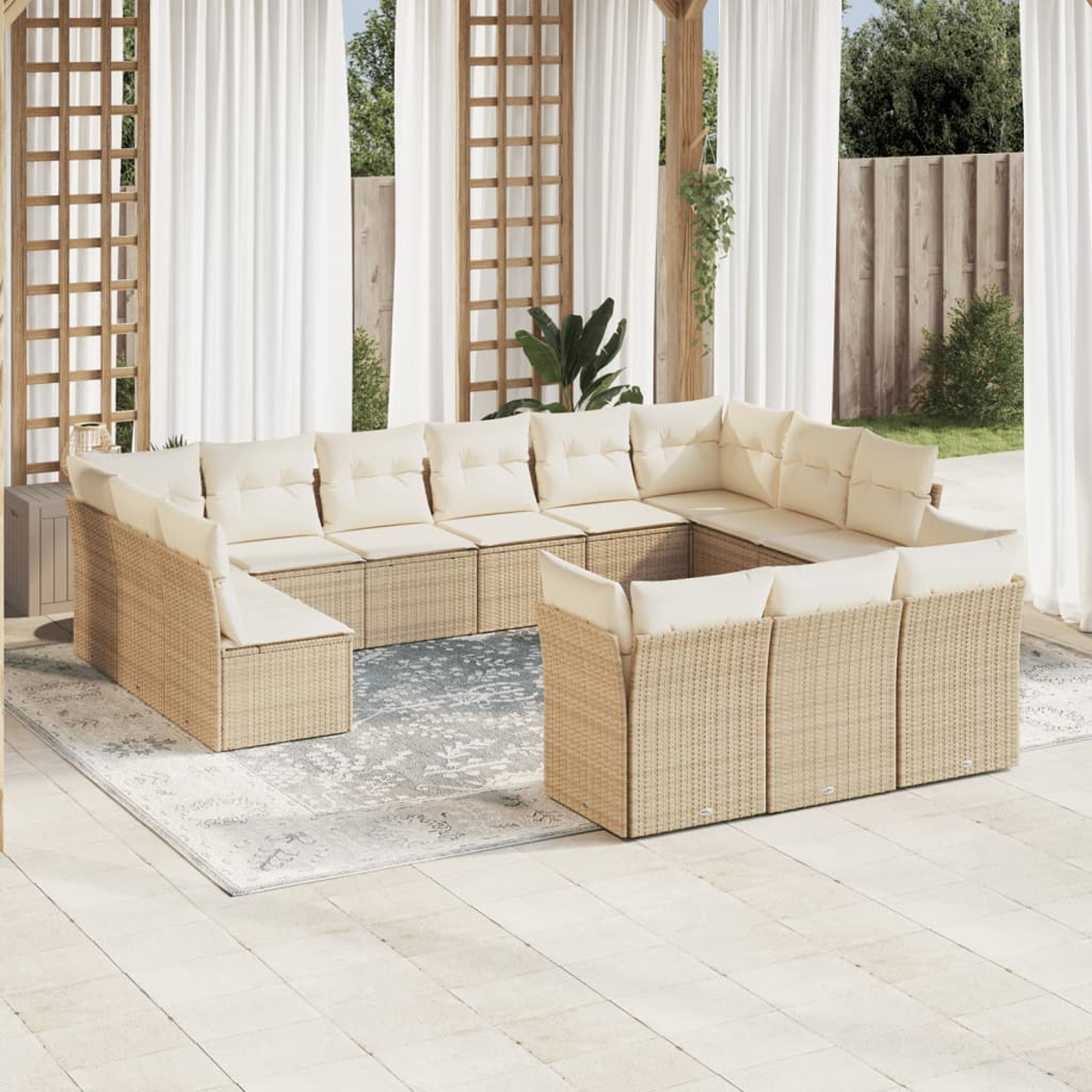 Ein großes Outdoor-Wicker-Sofaset mit beigefarbenen Kissen auf einer Terrasse mit Teppich.