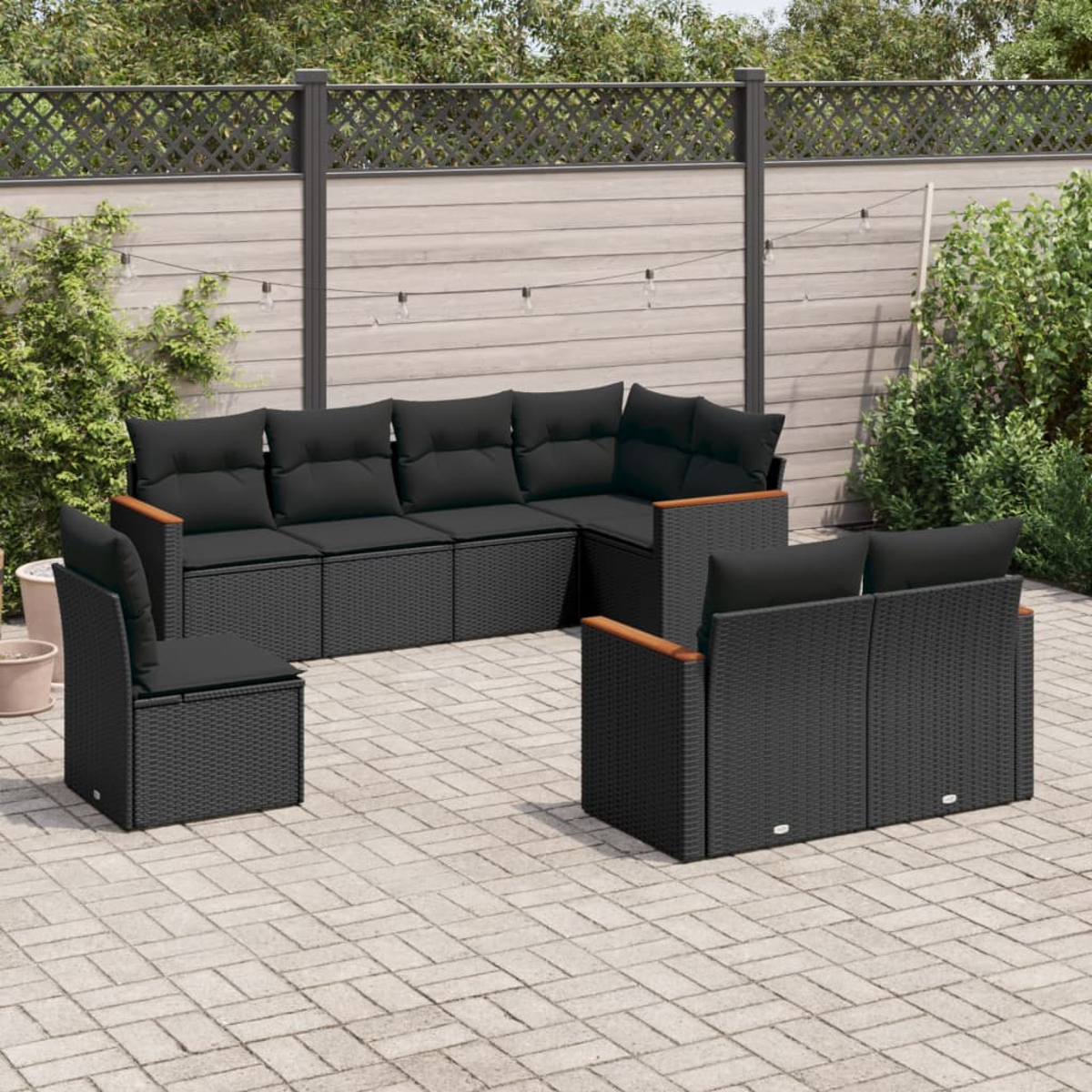 Schwarzes Outdoor-Möbelset aus Korbgeflecht auf einer Ziegelterrasse. Enthält ein Ecksofa, zwei Stühle und ein Loveseat.