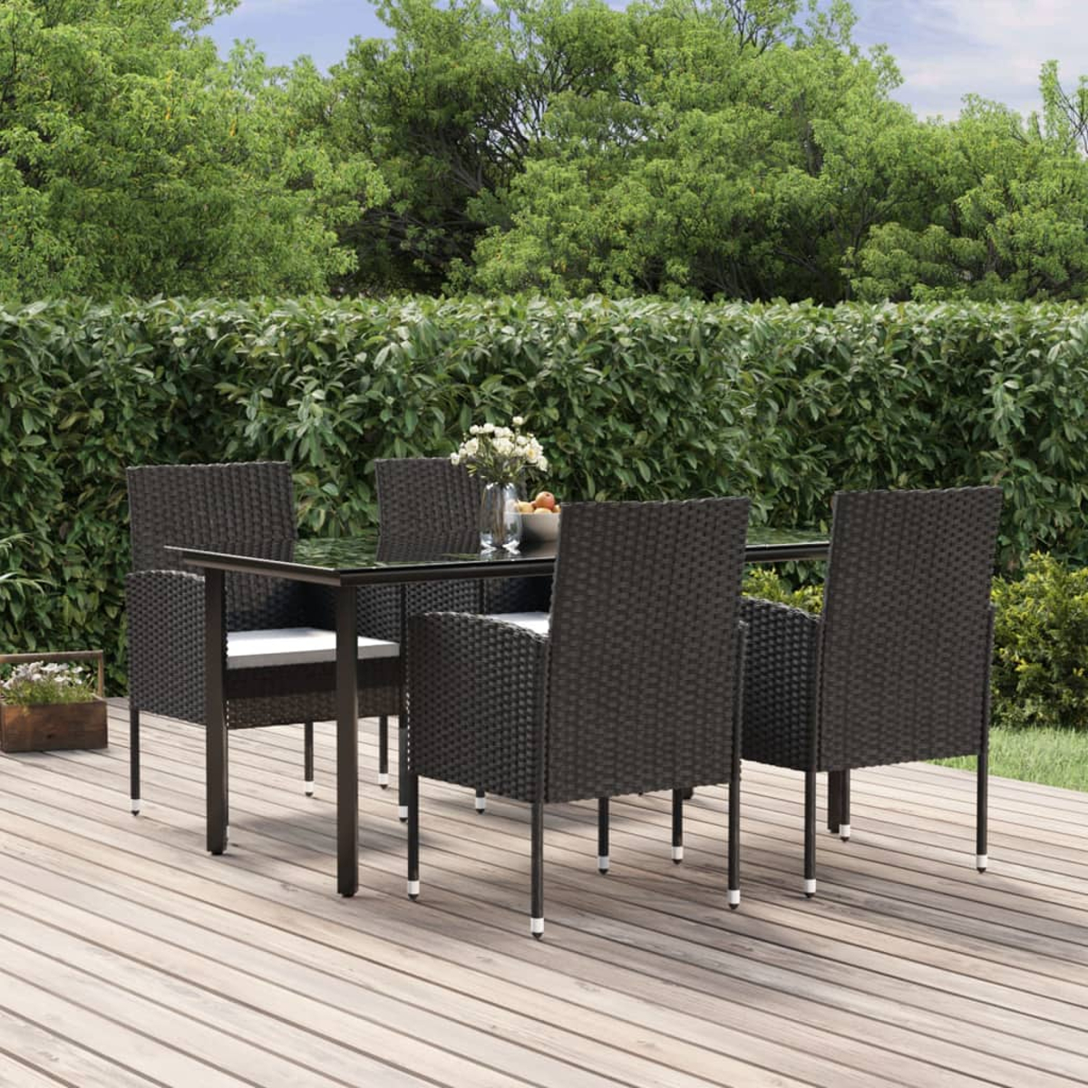 Essgruppe für den Außenbereich mit einem Tisch und vier Stühlen auf einer Holzterrasse.