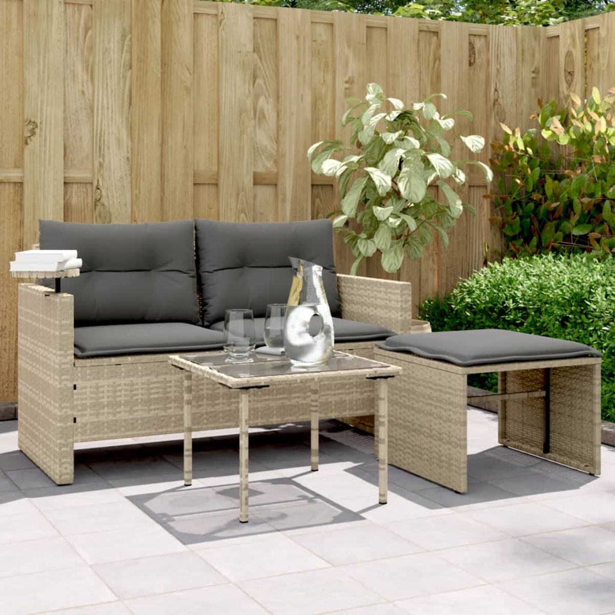Divano a due posti, tavolo e pouf. Rattan beige con cuscini grigi e un tavolo di vetro.