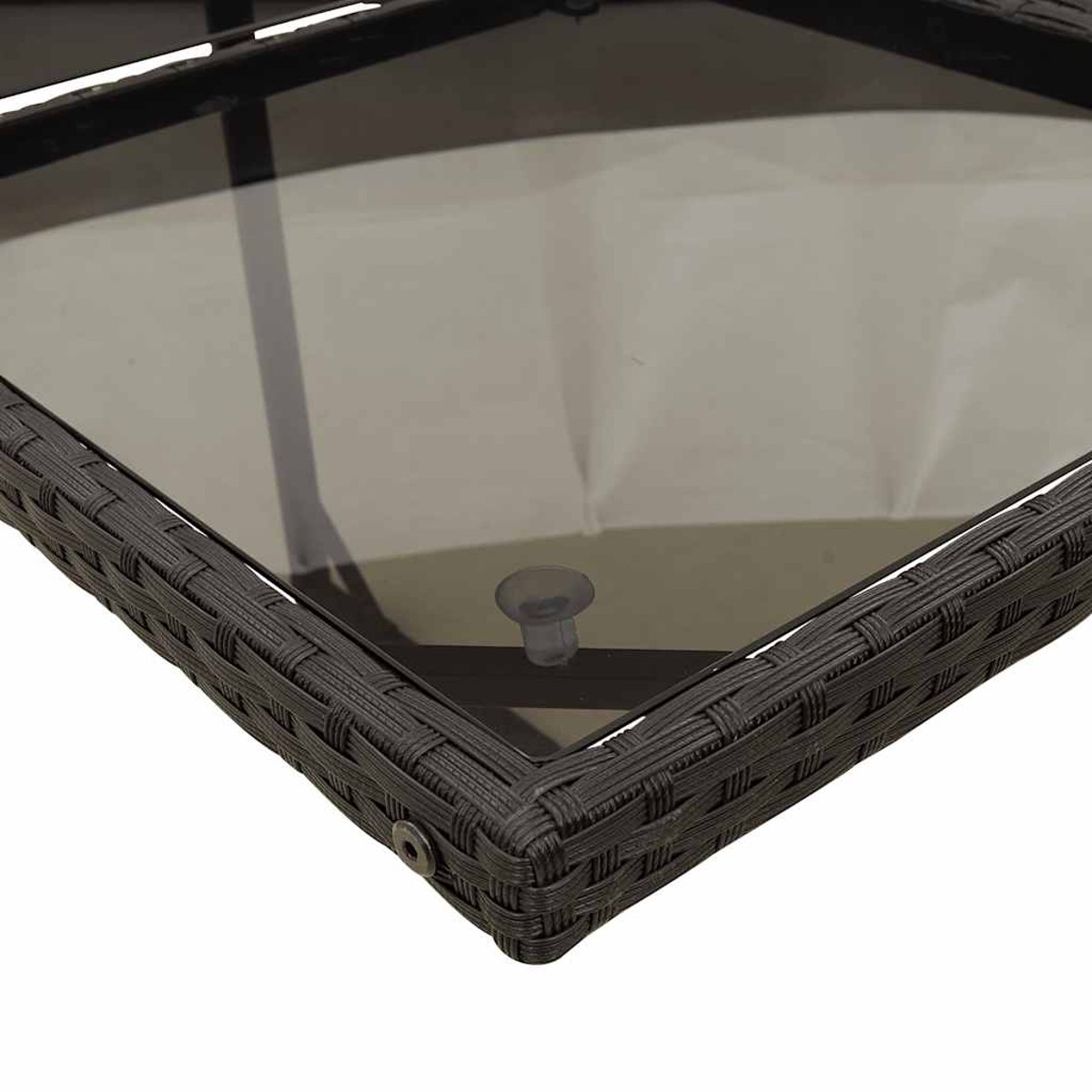 Primo piano di un angolo di tavolo con piano in vetro e intreccio in rattan marrone.