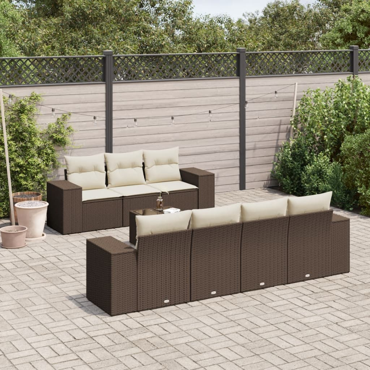 Una scena di patio all'aperto con un set di divani in rattan e un patio in mattoni. Mobili marroni e cuscini beige.