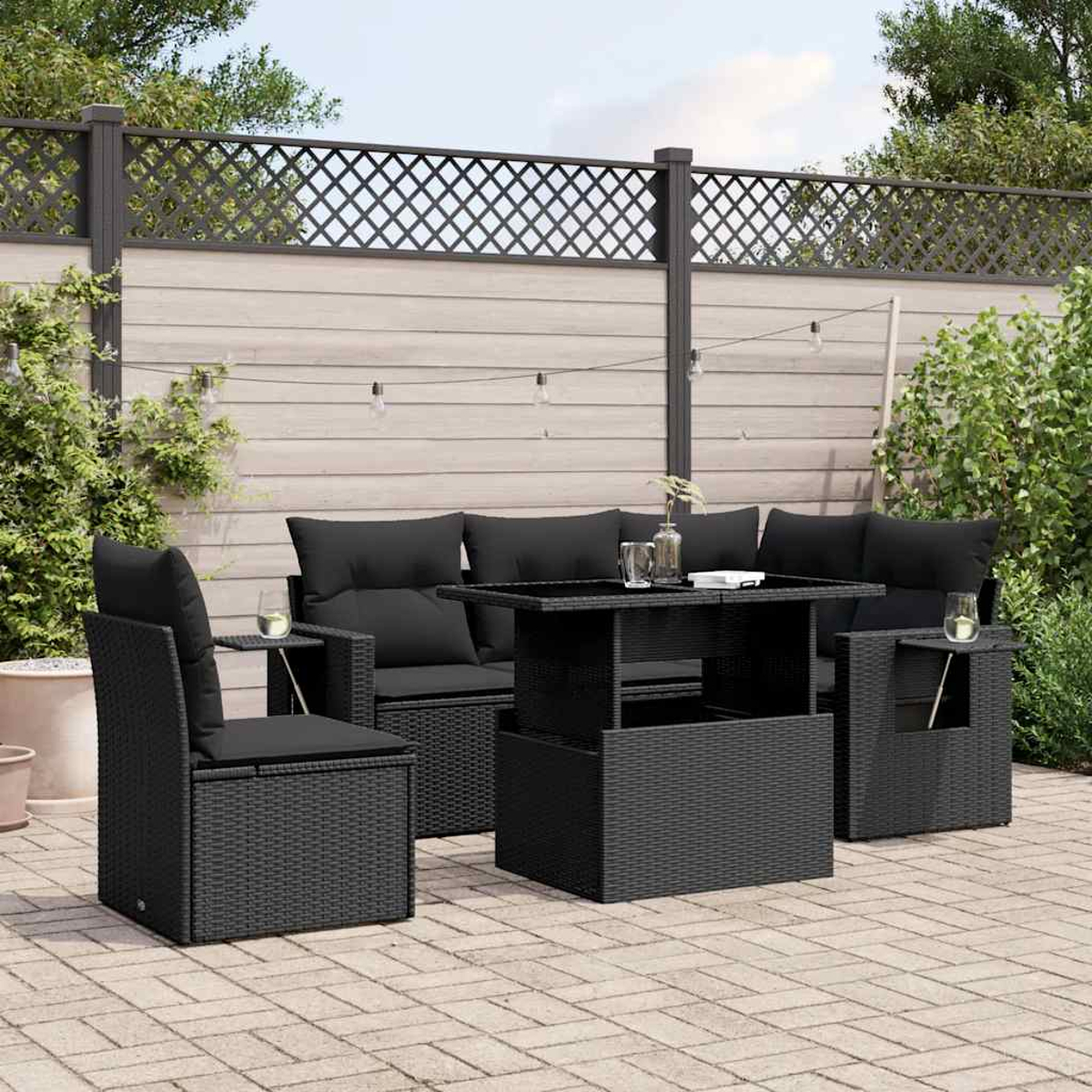 Eine Szene auf der Außenterrasse mit schwarzem Rattanmöbel-Set, schwarzen Kissen und einem Tisch.