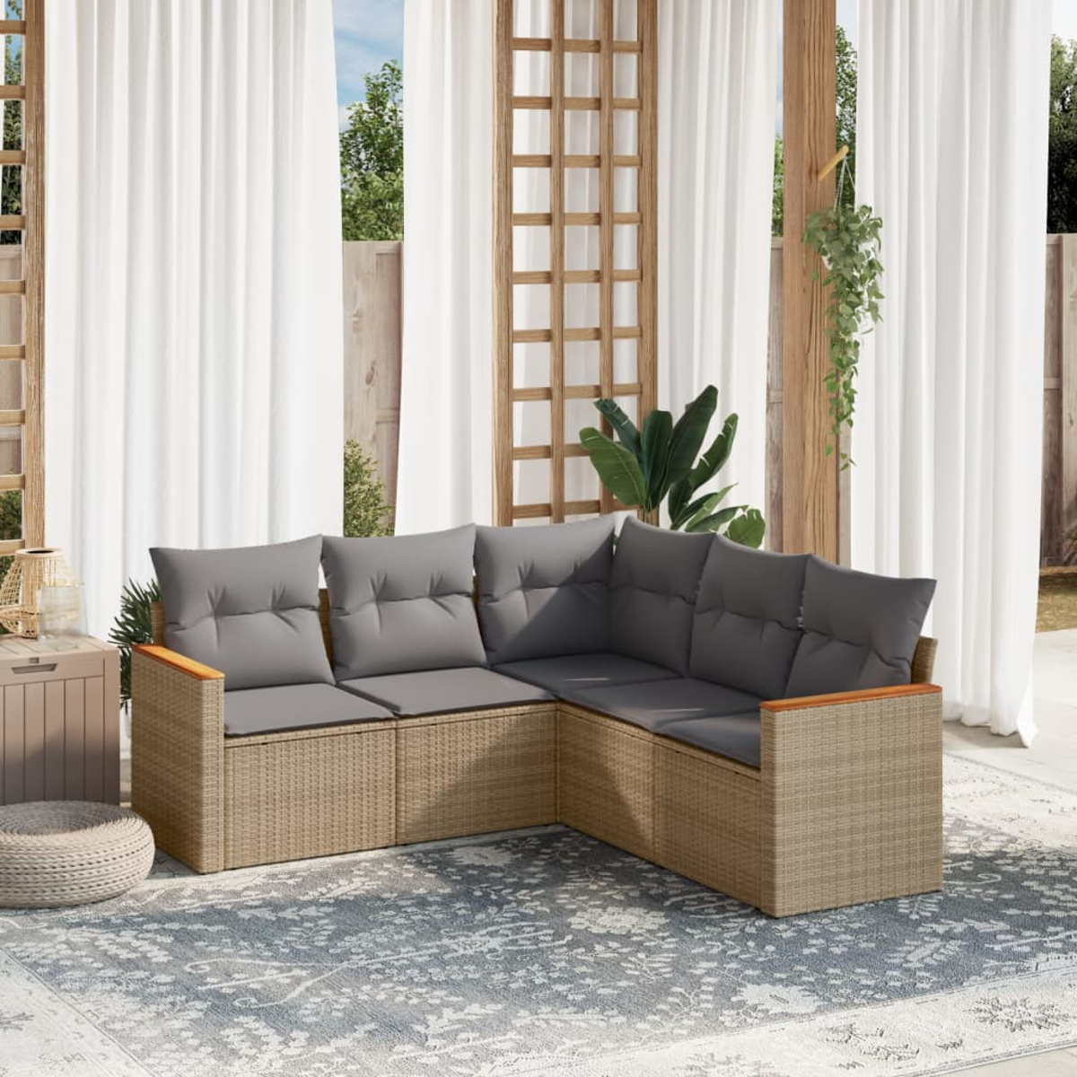 L-förmiges beiges gewebtes Outdoor-Sofa mit grauen Kissen. Vorhänge und Spalier im Hintergrund.