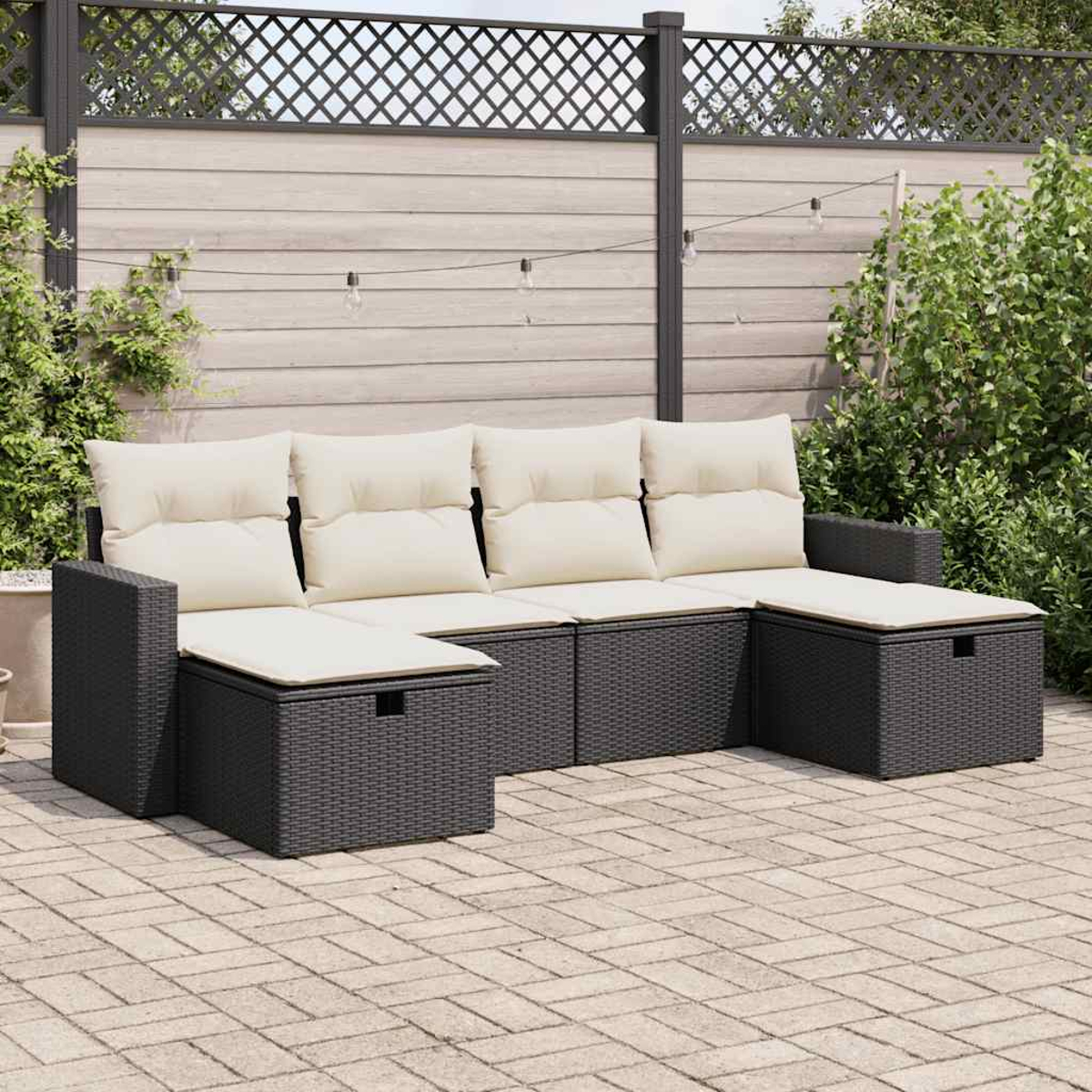 Ein dunkelgraues Rattan-Sofa für den Außenbereich mit cremefarbenen Kissen.