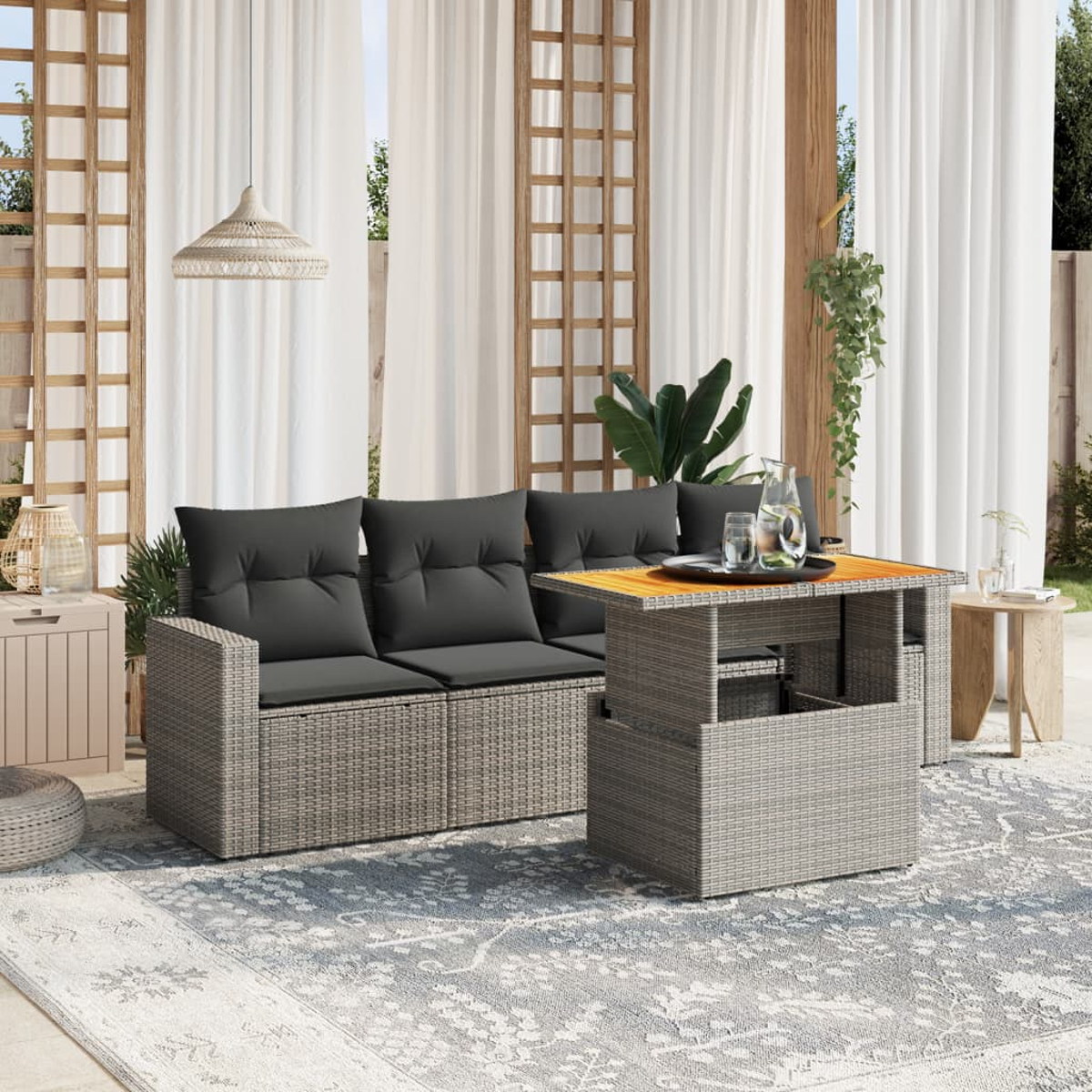 Set di sedute da esterno in vimini grigio con cuscini grigi, tavolo sollevabile e tappeto fantasia, con tende.
