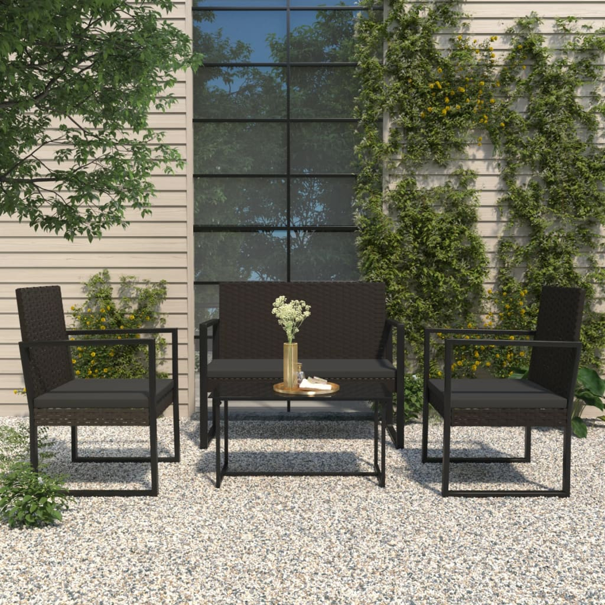 Outdoor-Sitzgruppe auf Kies. Enthält ein Sofa, zwei Stühle und einen Tisch mit Blumen und Dekoration.