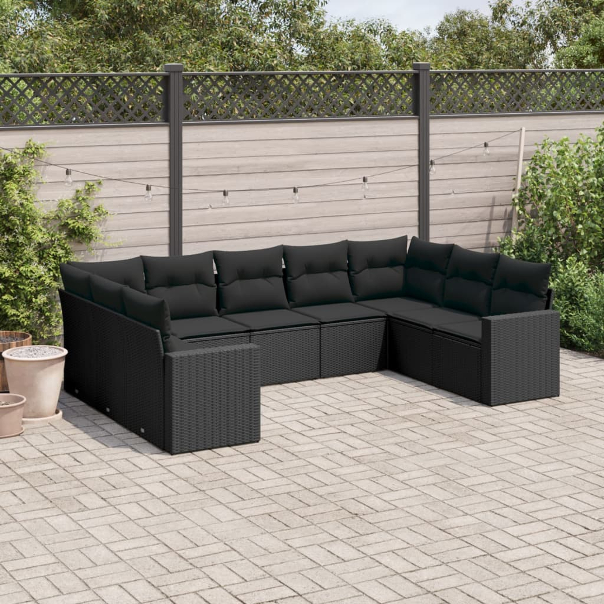 Schwarzes Outdoor-Sofaset mit schwarzen Kissen, in einer Outdoor-Umgebung.