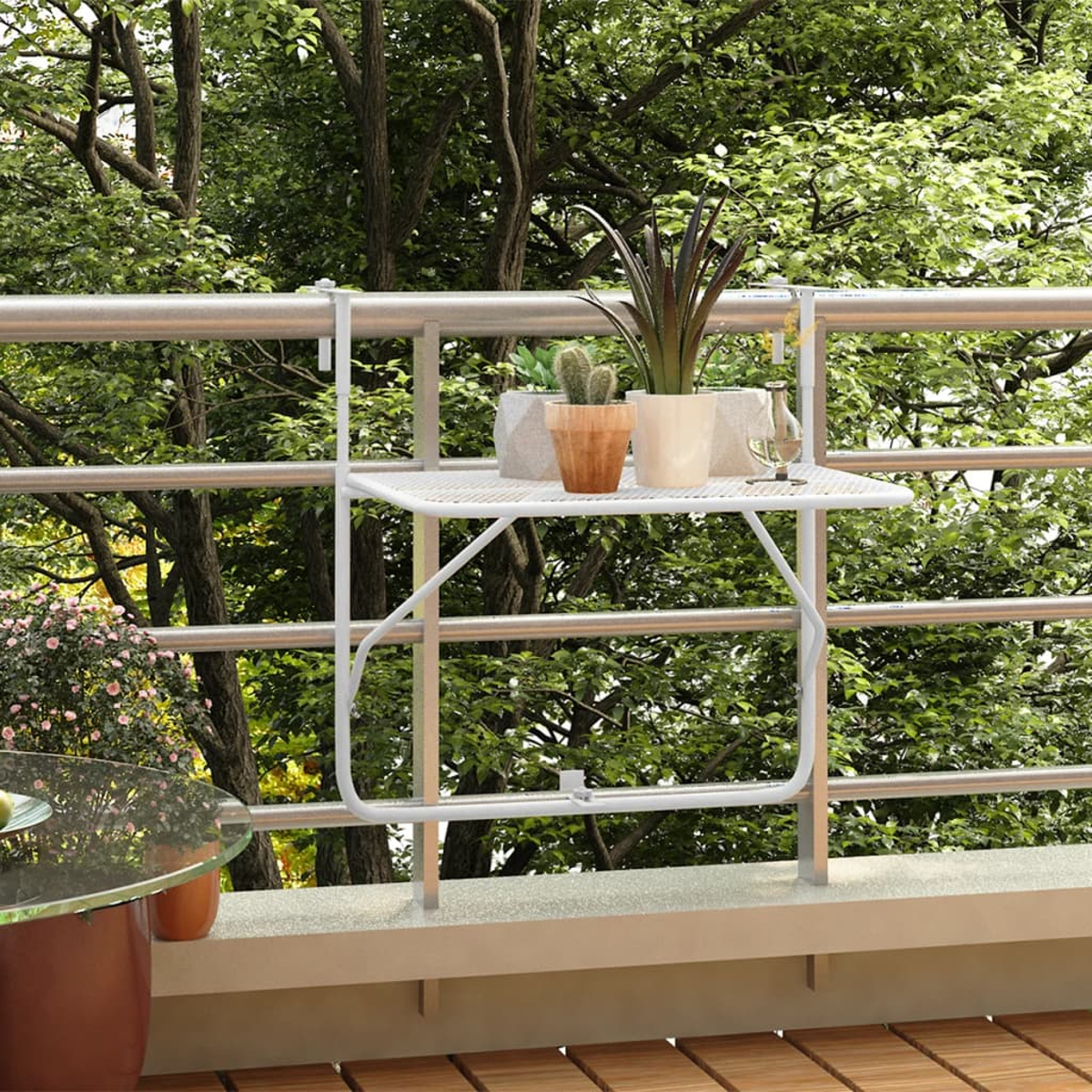 Ein Balkon mit weißem Metallgeländer und einem kleinen weißen Tisch mit Pflanzen.