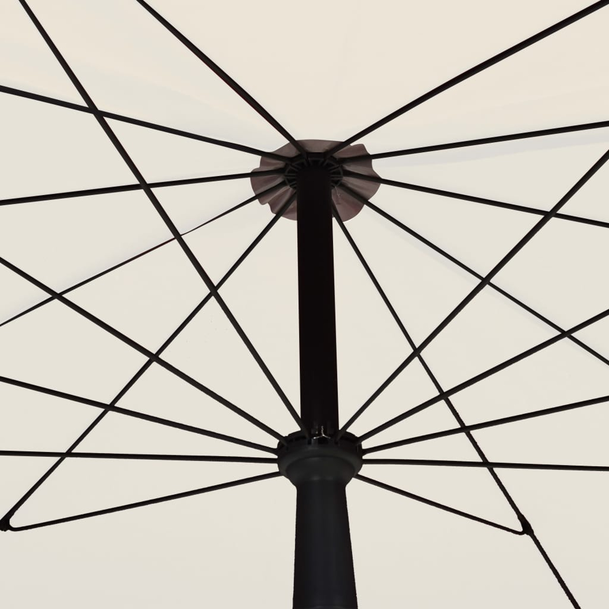 Ansicht von unten eines offenen weißen Regenschirms. Schwarze Stützstruktur strahlt aus der Mitte aus.