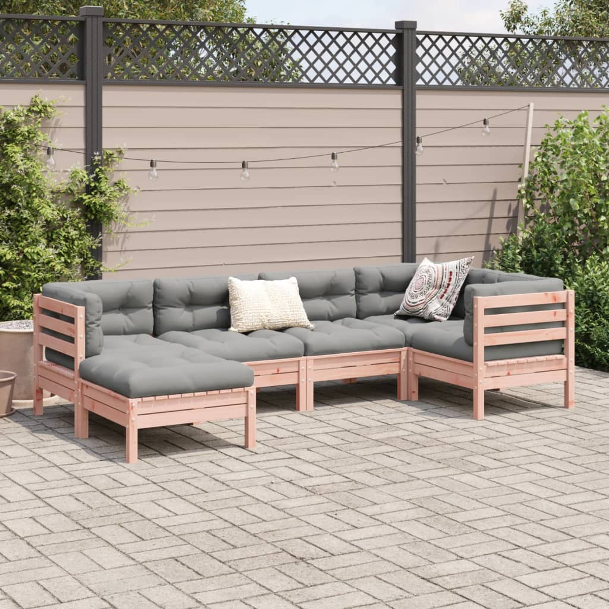 Outdoor-Ecksofa mit grauen Kissen und rosa Holzrahmen. Weiße und gemusterte Kissen auf dem Sofa auf der Terrasse.