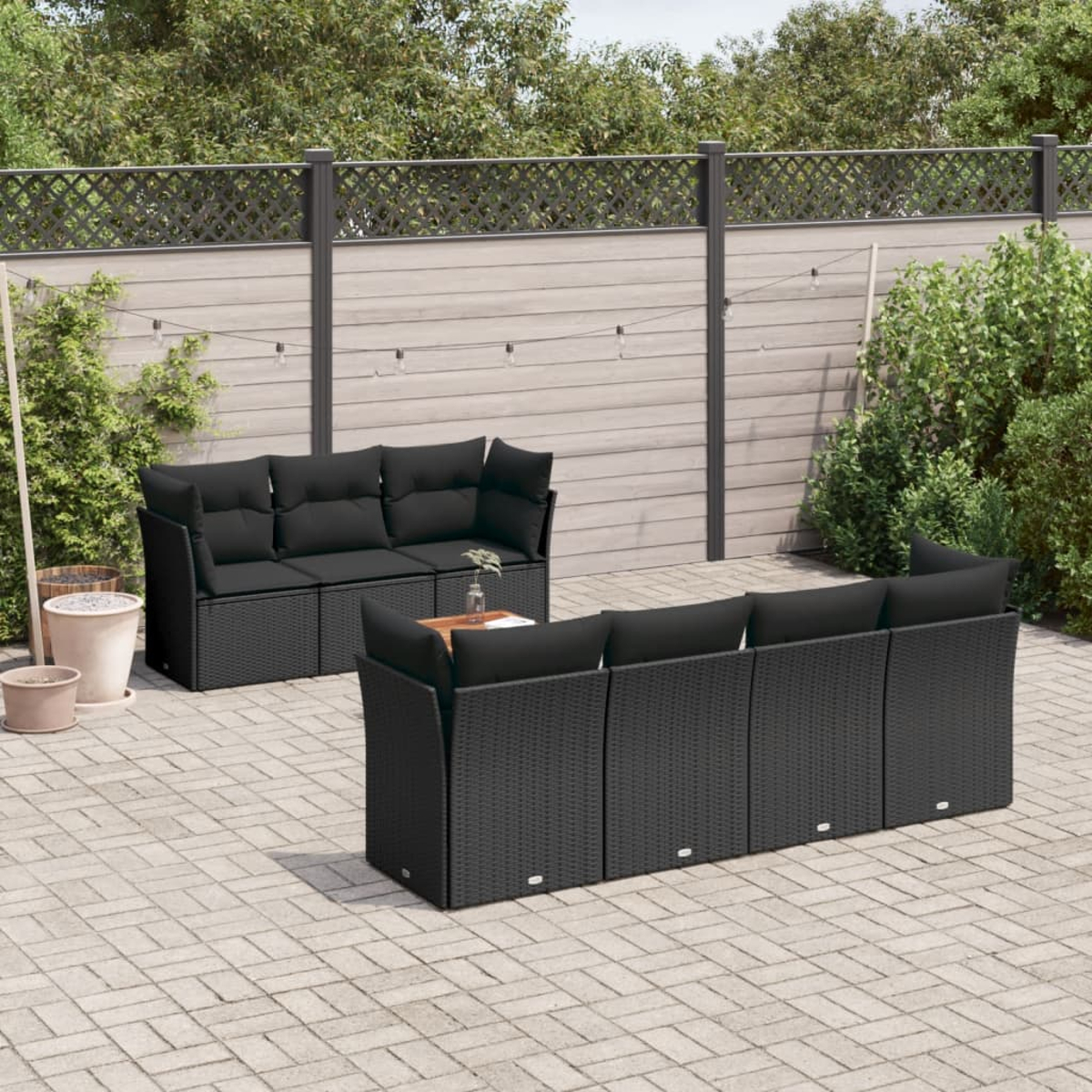 Schwarzes Outdoor-Möbelset auf einer Backstein-Terrasse, einschließlich Sofa und Tisch.