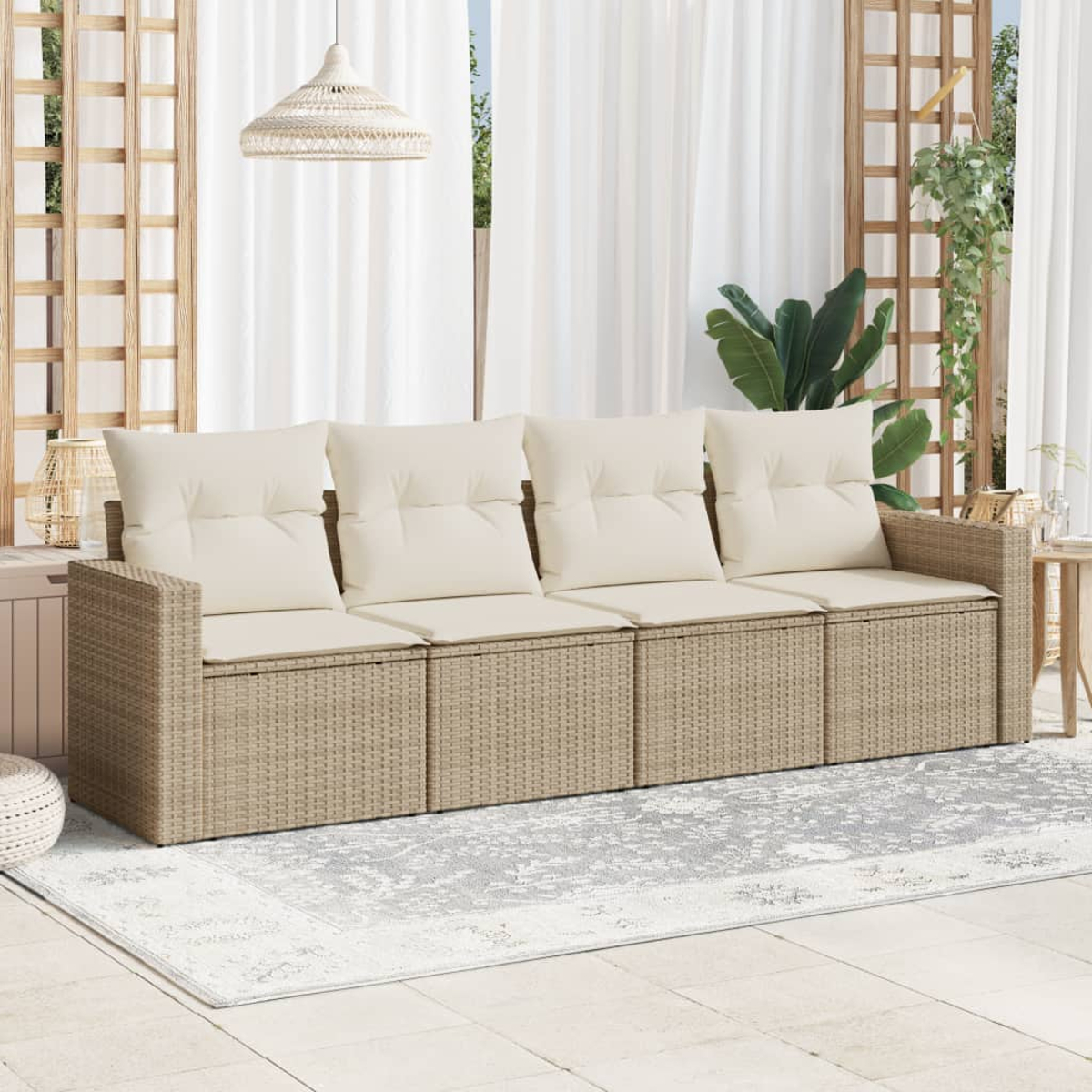 Ein beiges Korbmöbelsofa mit cremefarbenen Kissen auf einem gemusterten Teppich, auf einer Terrasse mit weißen Vorhängen.