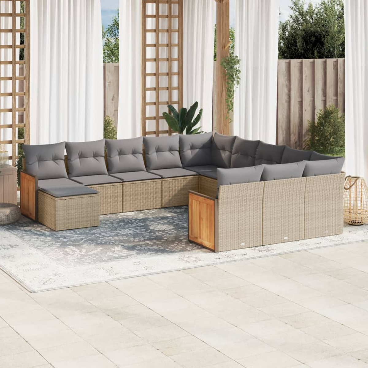 Beige Outdoor-Geflechtmöbel mit grauen Kissen, Tisch und Teppich. Holzakzente, weiße Vorhänge.