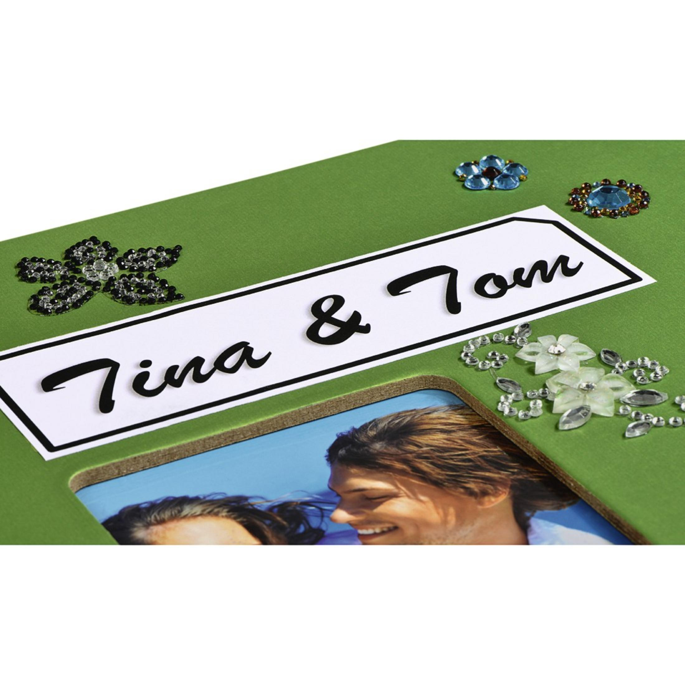 Strona albumu ze zdjęciami ze słowami "Tina & Tom" oraz ozdobnymi kwiatami i klejnotami.