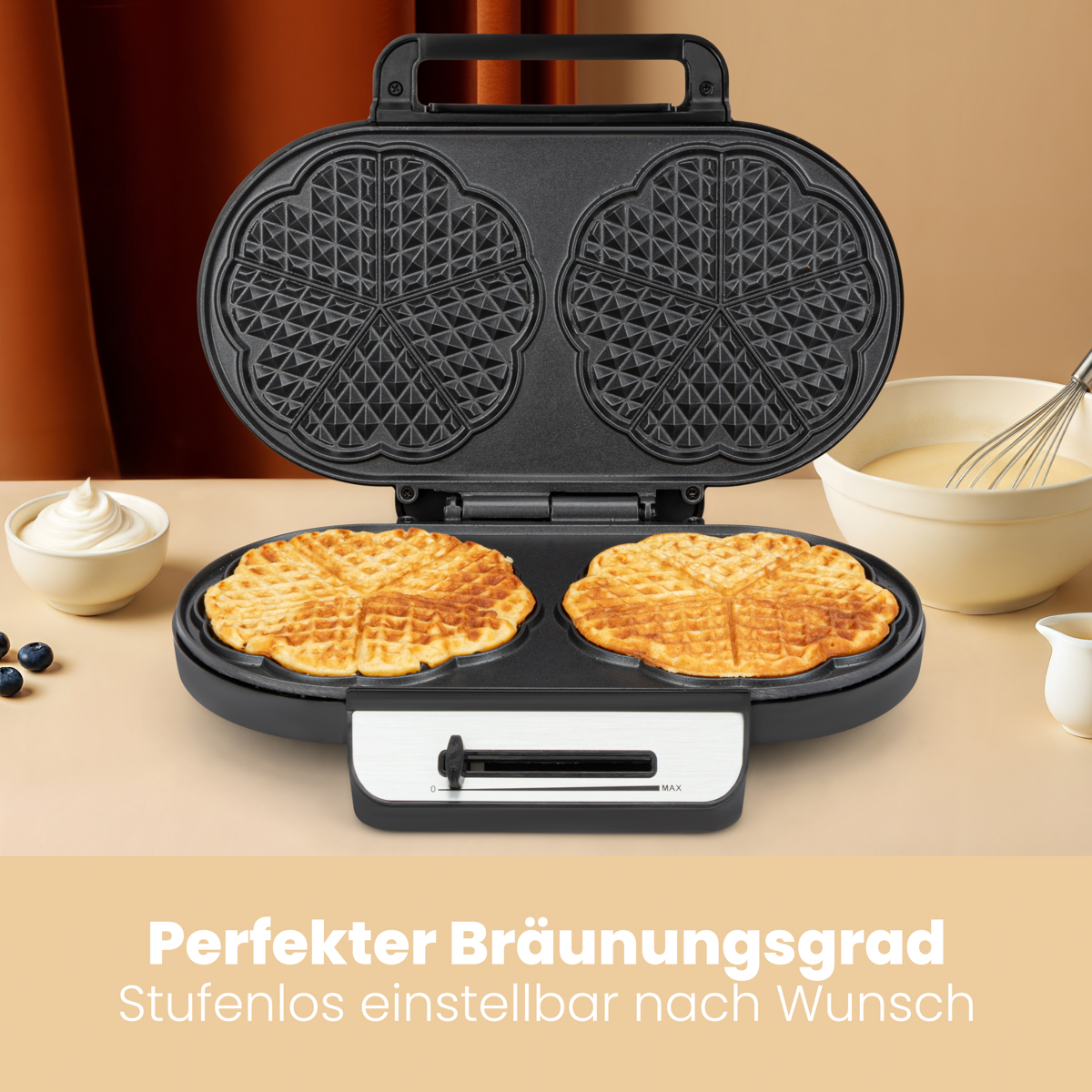 Czarna gofrownica z dwoma upieczonymi goframi. Ciasto, śmietana i jagody w tle.