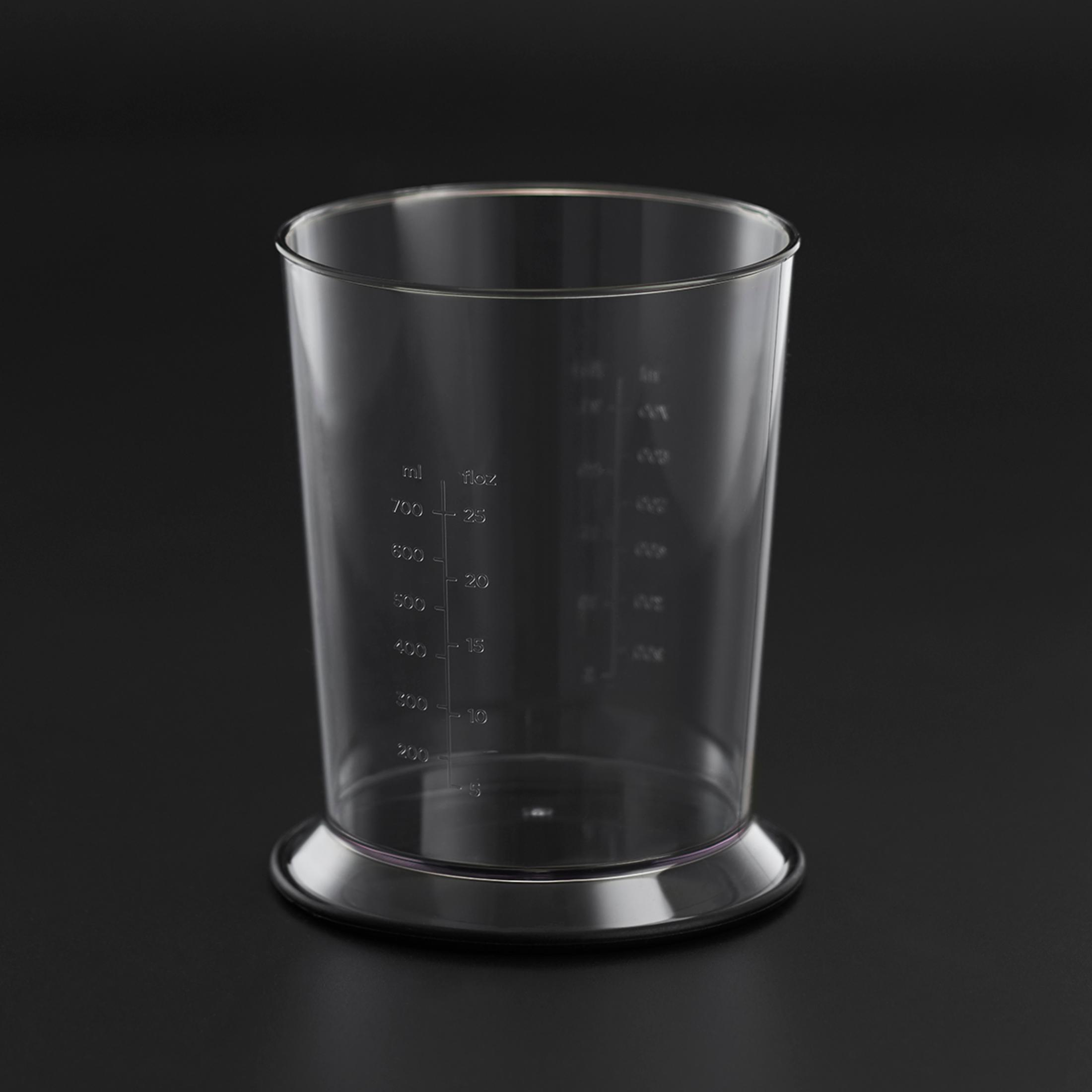 Przezroczysty, pusty kubek z miarką na czarnym tle. Ma oznaczenia pomiarowe.