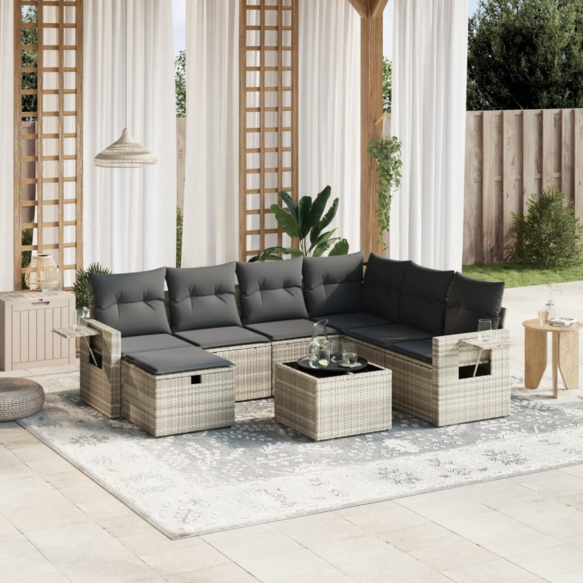 Outdoor-Ecksofa mit Kissen, Couchtisch und Teppich. Hintergrund umfasst Vorhänge und Pflanzen.