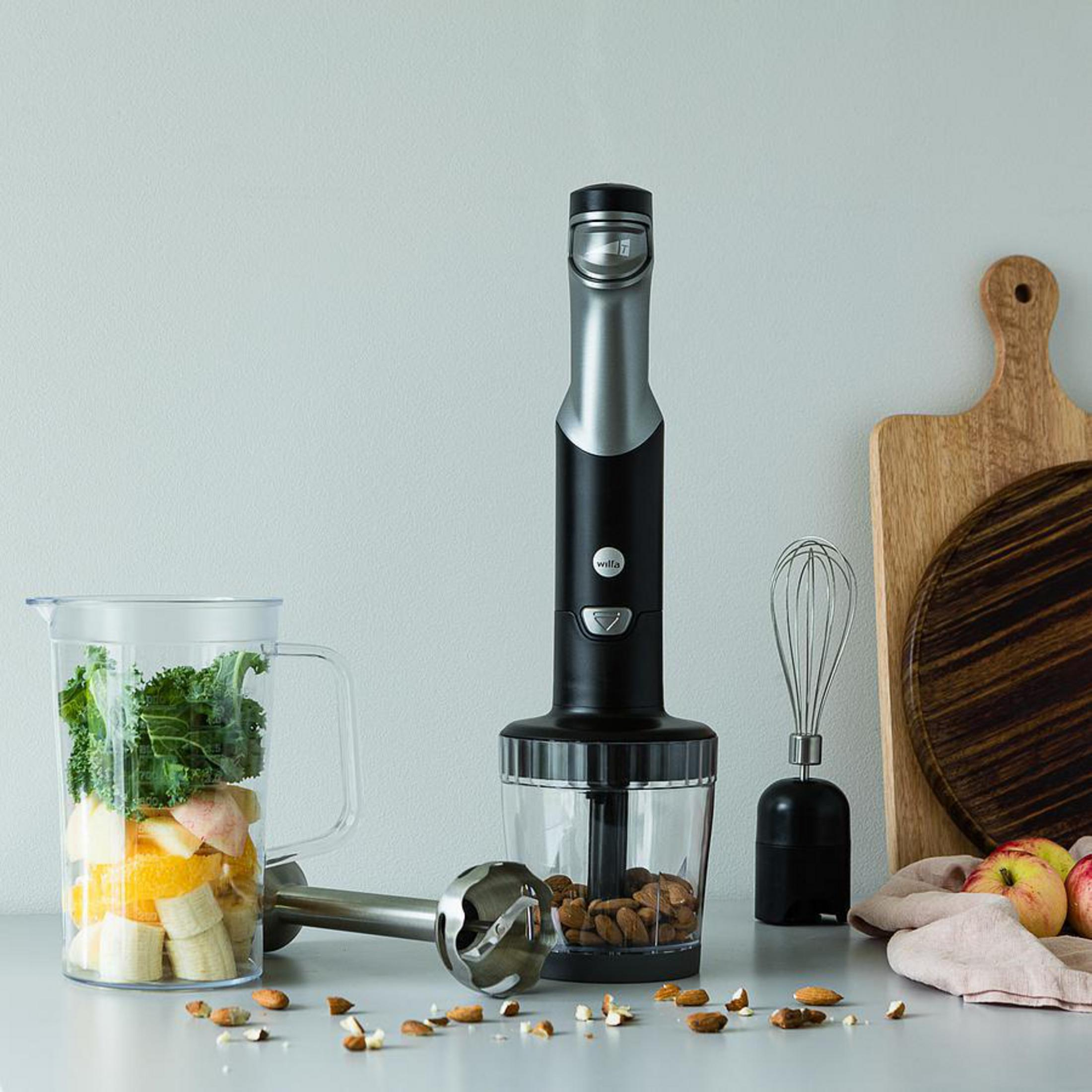 Frullatore a immersione con ingredienti in una brocca. Ambiente cucina.