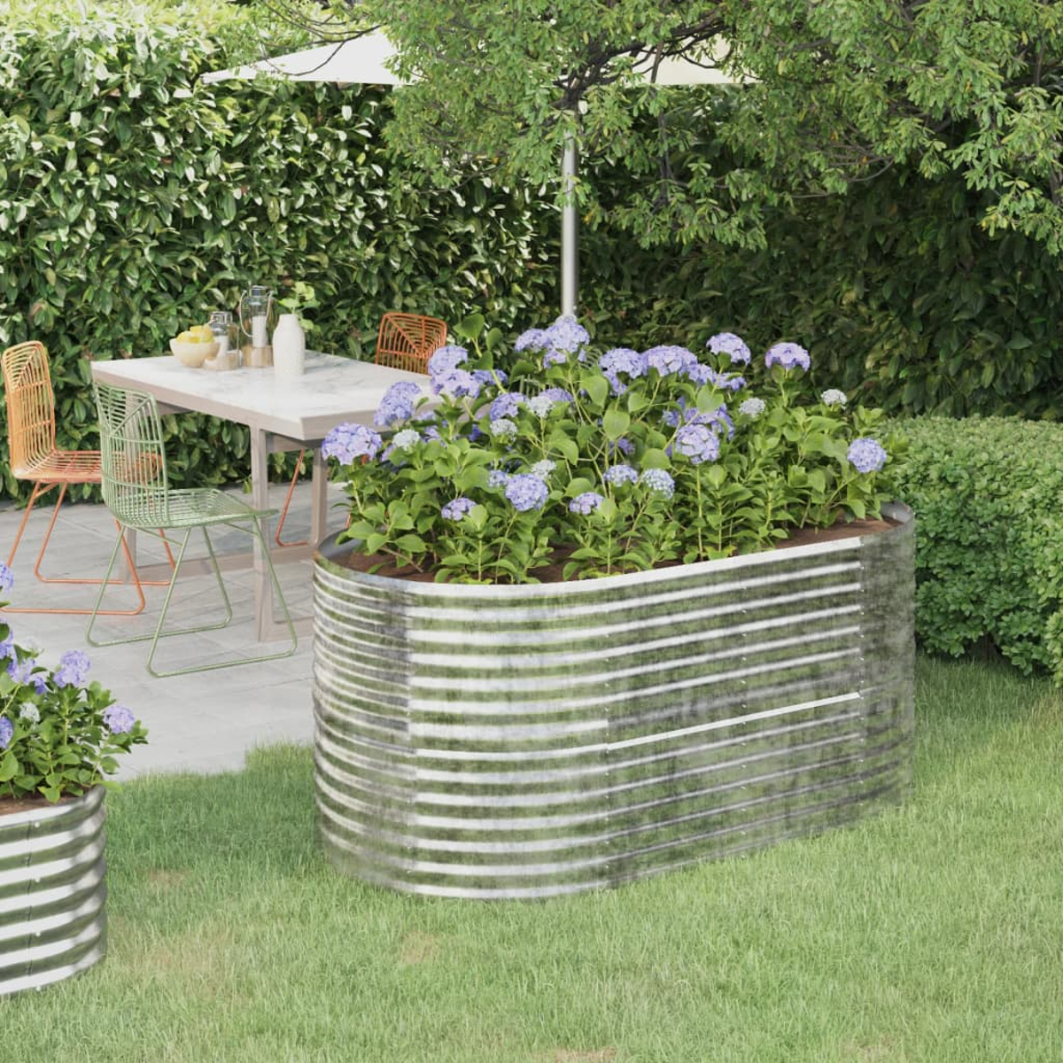 Metallpflanzer mit blauen Blumen und Gartenszene mit Tisch, Stühlen und Schirm.