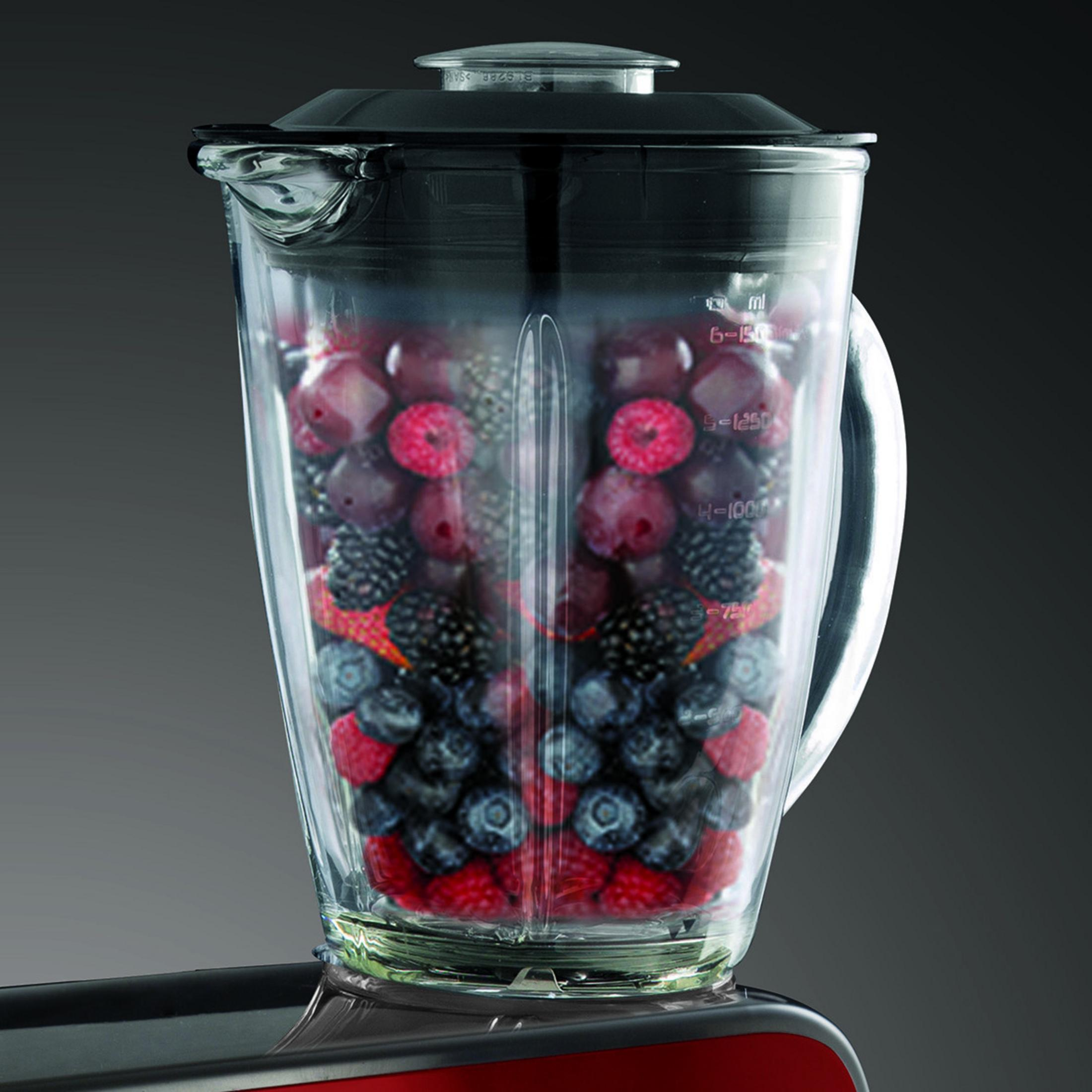 Mixerbehälter gefüllt mit verschiedenen Beeren, Nahaufnahme der Zutaten und der Struktur des Behälters.