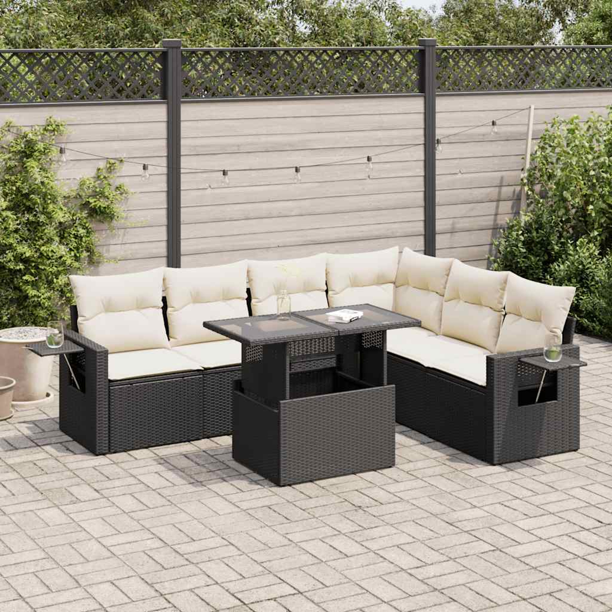 Set di mobili da esterno: divano in rattan grigio scuro con cuscini bianchi e tavolo.