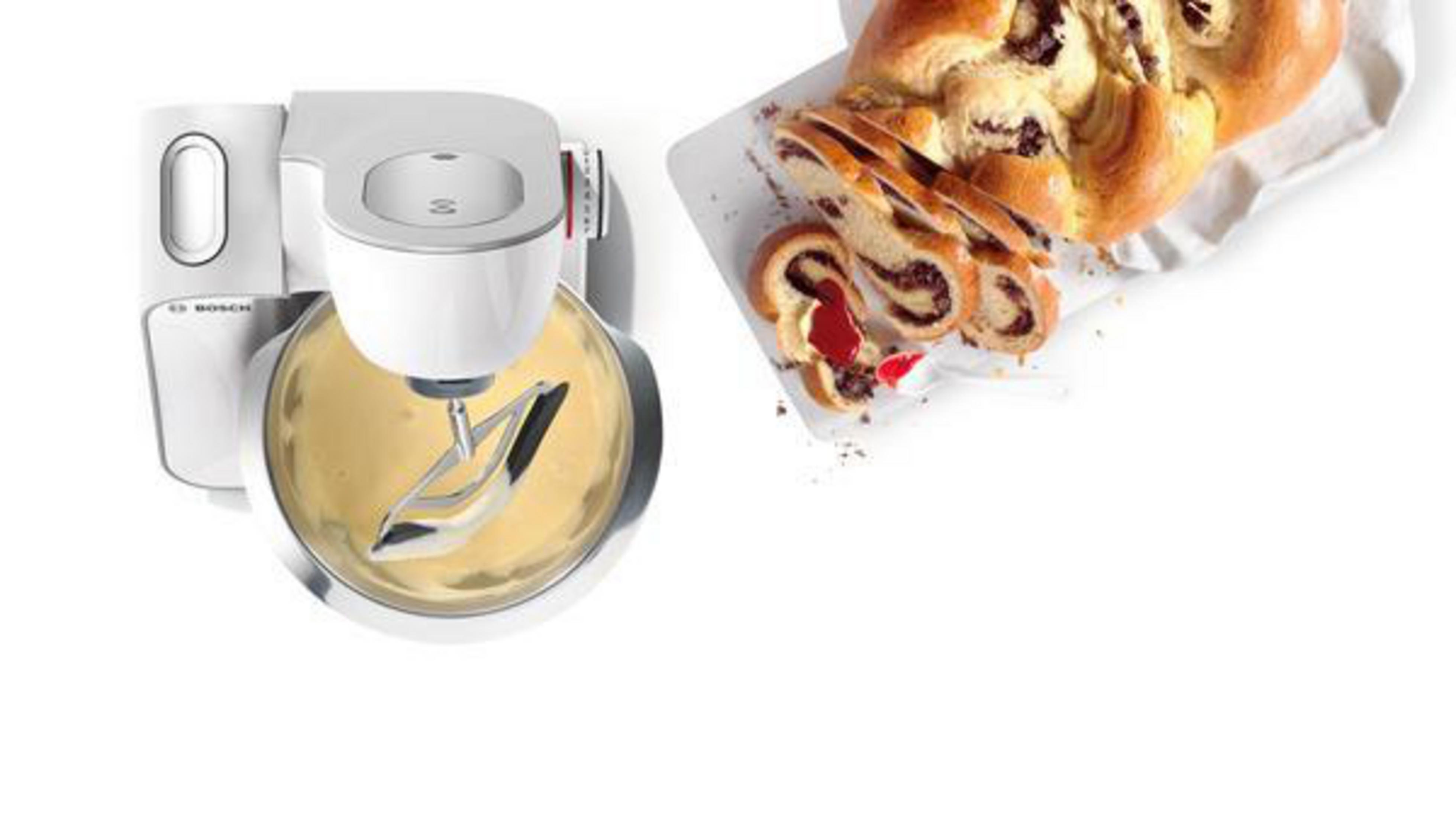 Küchenmixer mit Teig in einer Schüssel und eine Scheibe Brot mit Füllung.