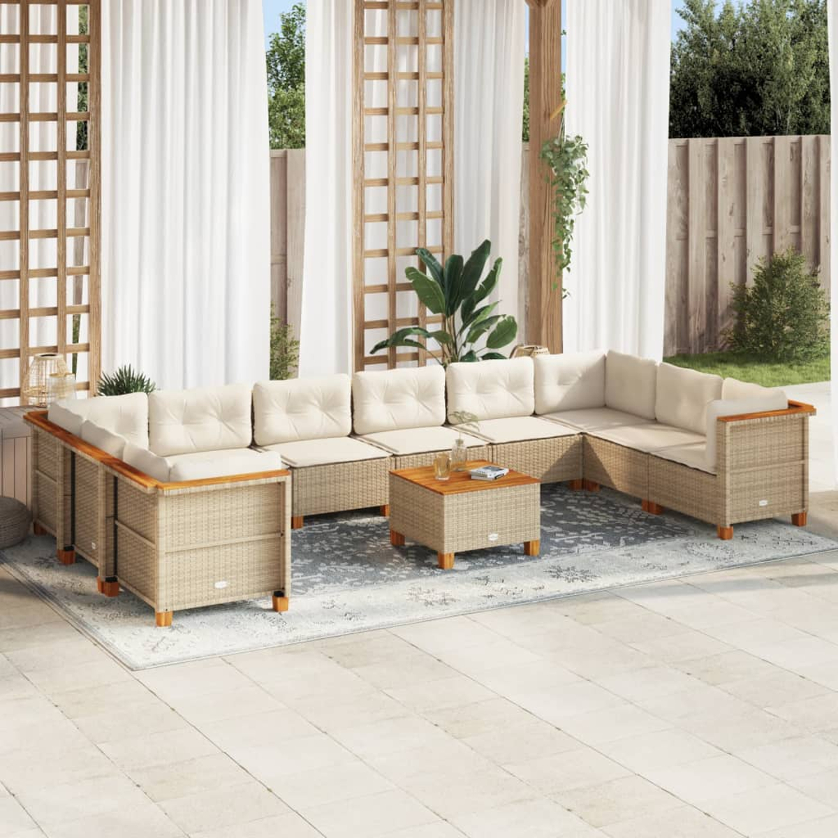 Un set da patio beige intrecciato con cuscini color crema e un tavolo in legno. È su un patio con un tappeto.