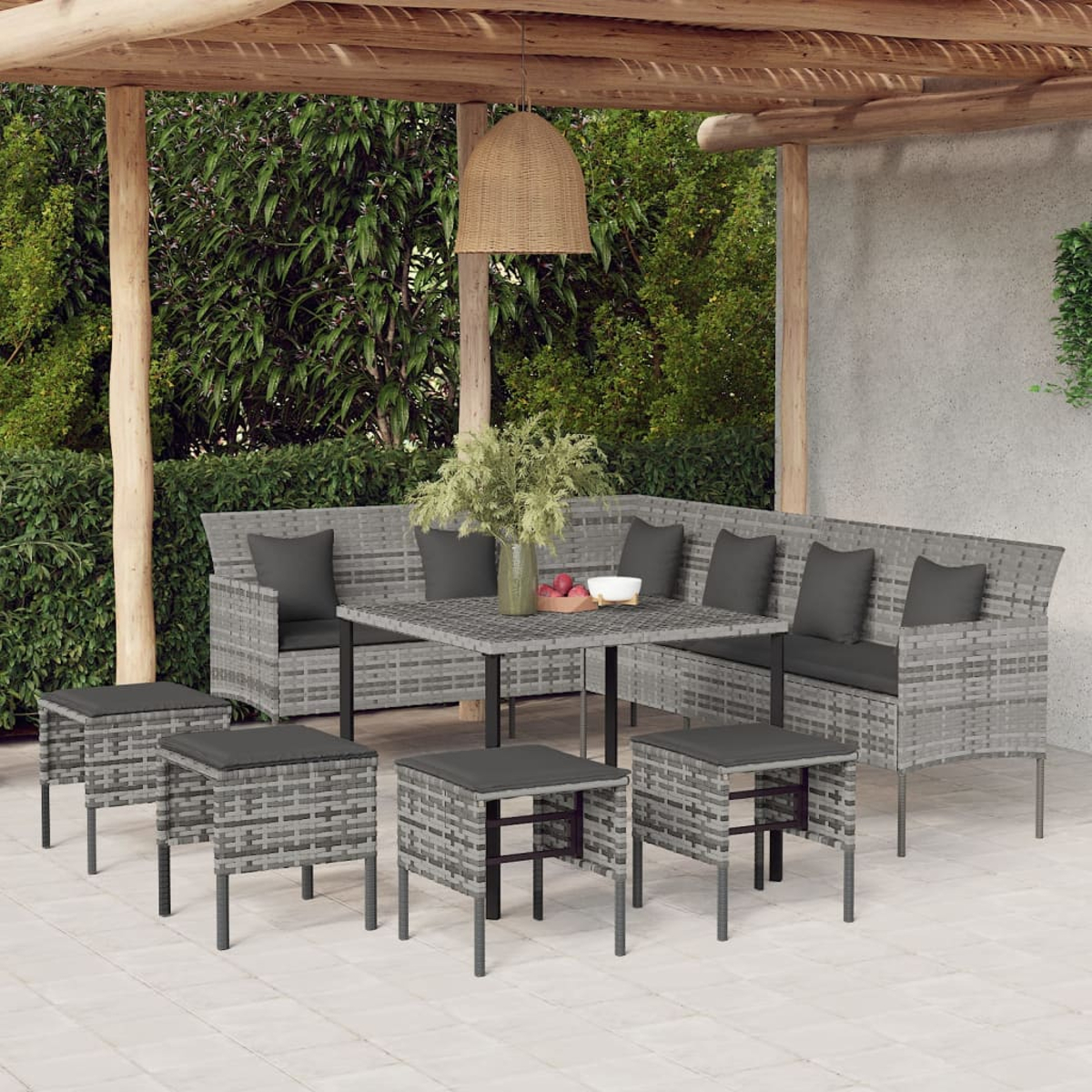 Outdoor-Rattan-Möbelset mit grauen Kissen unter einer Pergola. Tisch mit Hockern.
