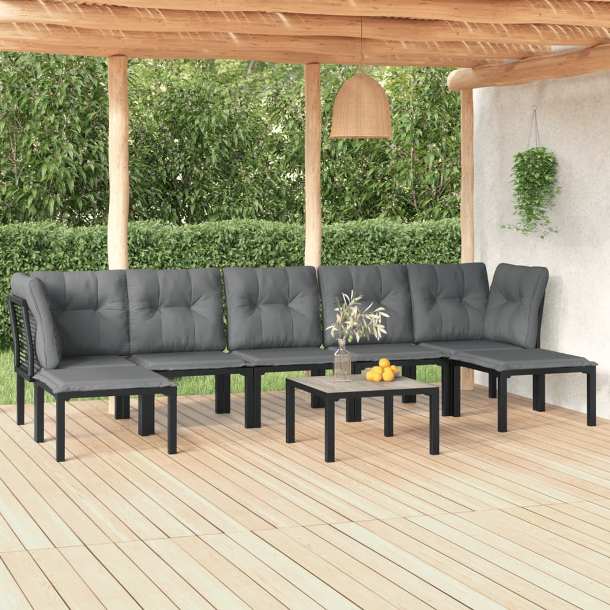 Outdoor-Ecksofa mit grauen Kissen und einem kleinen Tisch. Das Setup ist auf einem Holzdeck.