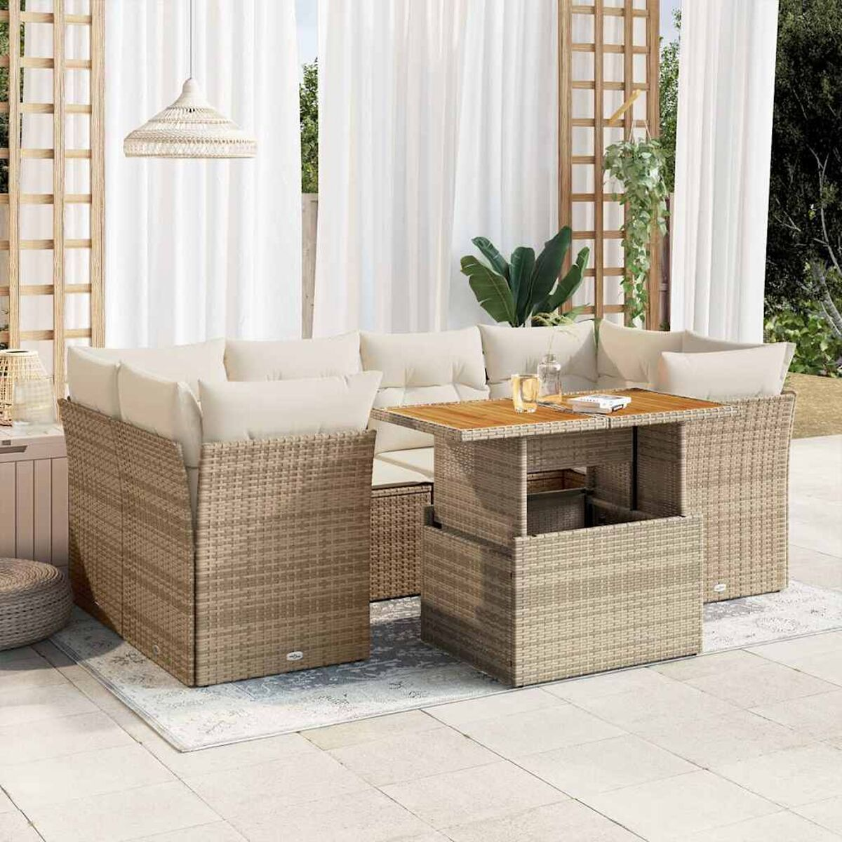 Un set di mobili da esterno in vimini beige su un patio. Include tavolo, divano e sedie.