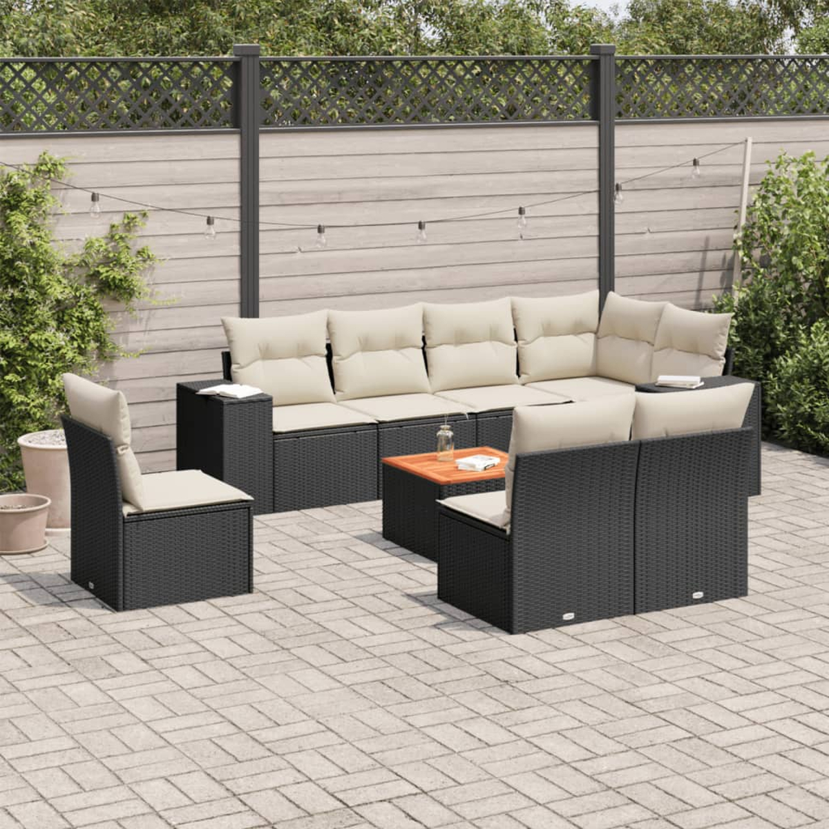 Outdoor-Wohnset mit schwarzen Rattanmöbeln und beigen Kissen. Auf einer Ziegelterrasse.