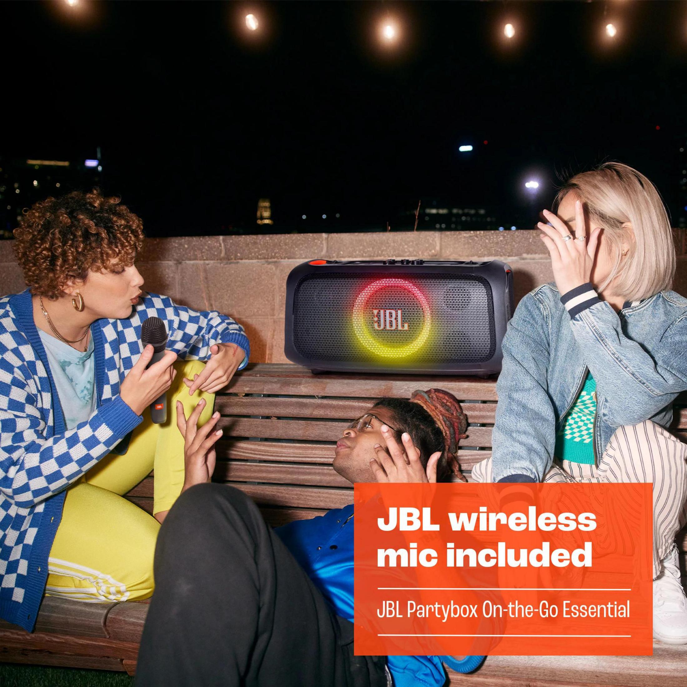 Trois personnes interagissent avec une enceinte JBL et un microphone.