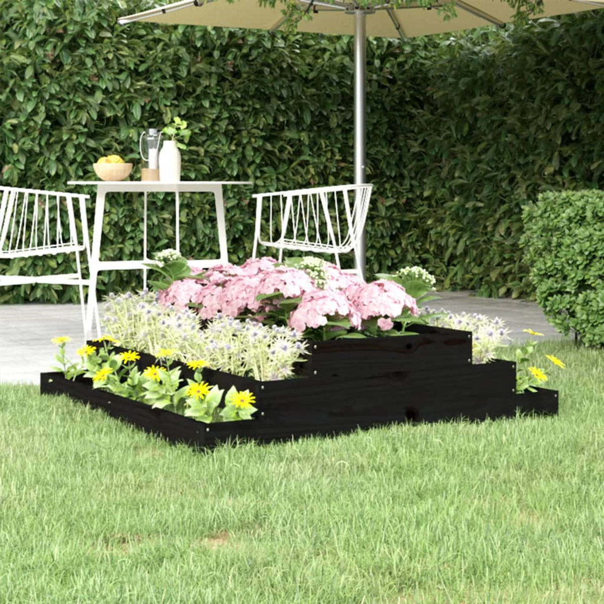 Schwarzer, gestufter Holzpflanzer mit Blumen, Gras und einem Schirm im Hintergrund.