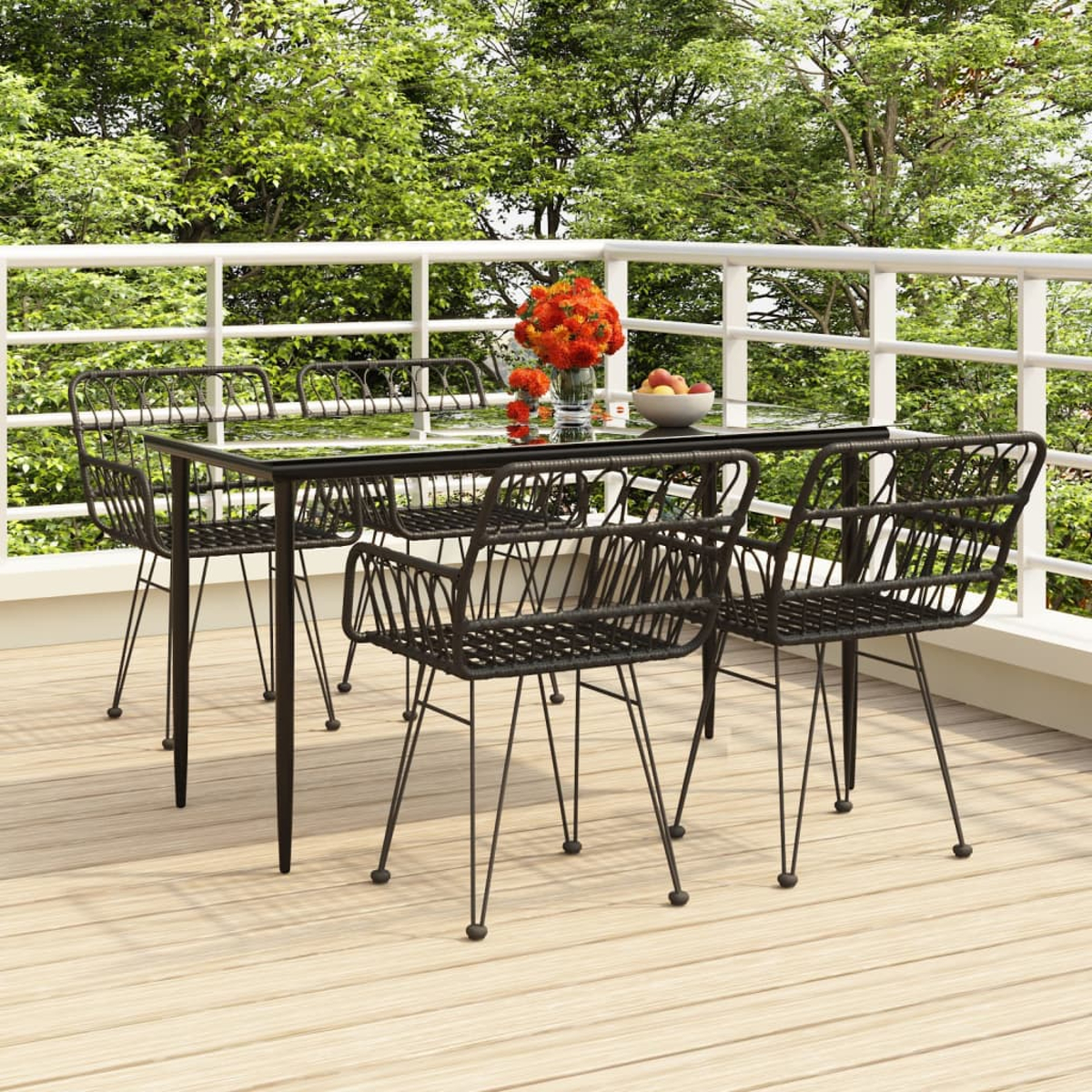 Ein Terrassenset mit Tisch, vier Stühlen und Blumen, auf einem Deck mit Bäumen im Hintergrund.