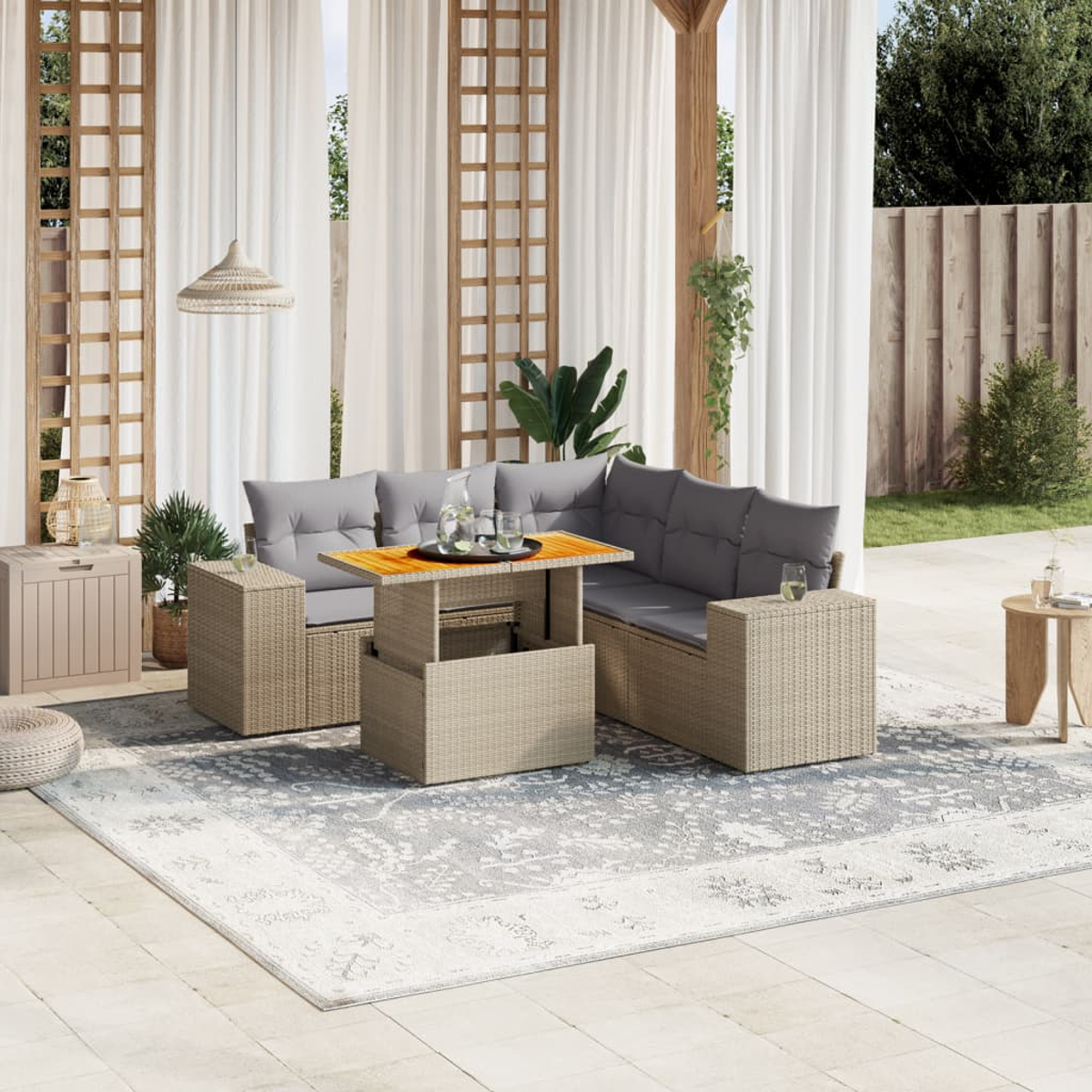 Gartenmöbel mit grauen Kissen und einem Holztisch auf einem gemusterten Teppich.