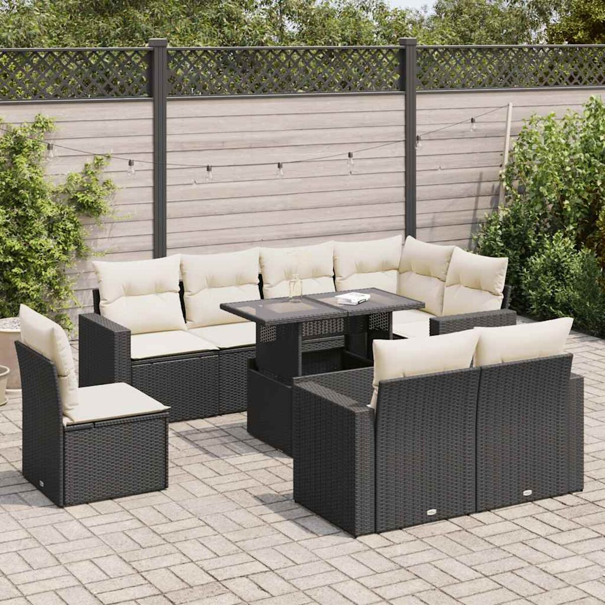 Un set da patio esterno con mobili in rattan nero e cuscini beige e un tavolo.