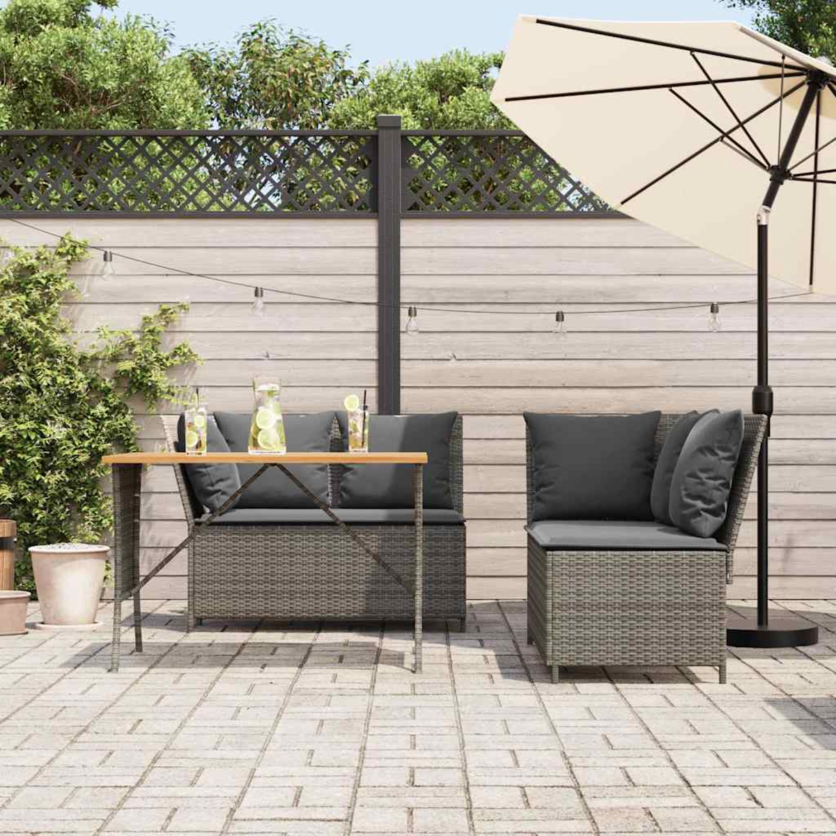 Scena di patio all'aperto, due poltrone in vimini grigie, tavolo e ombrellone color crema. Recinzione in legno.