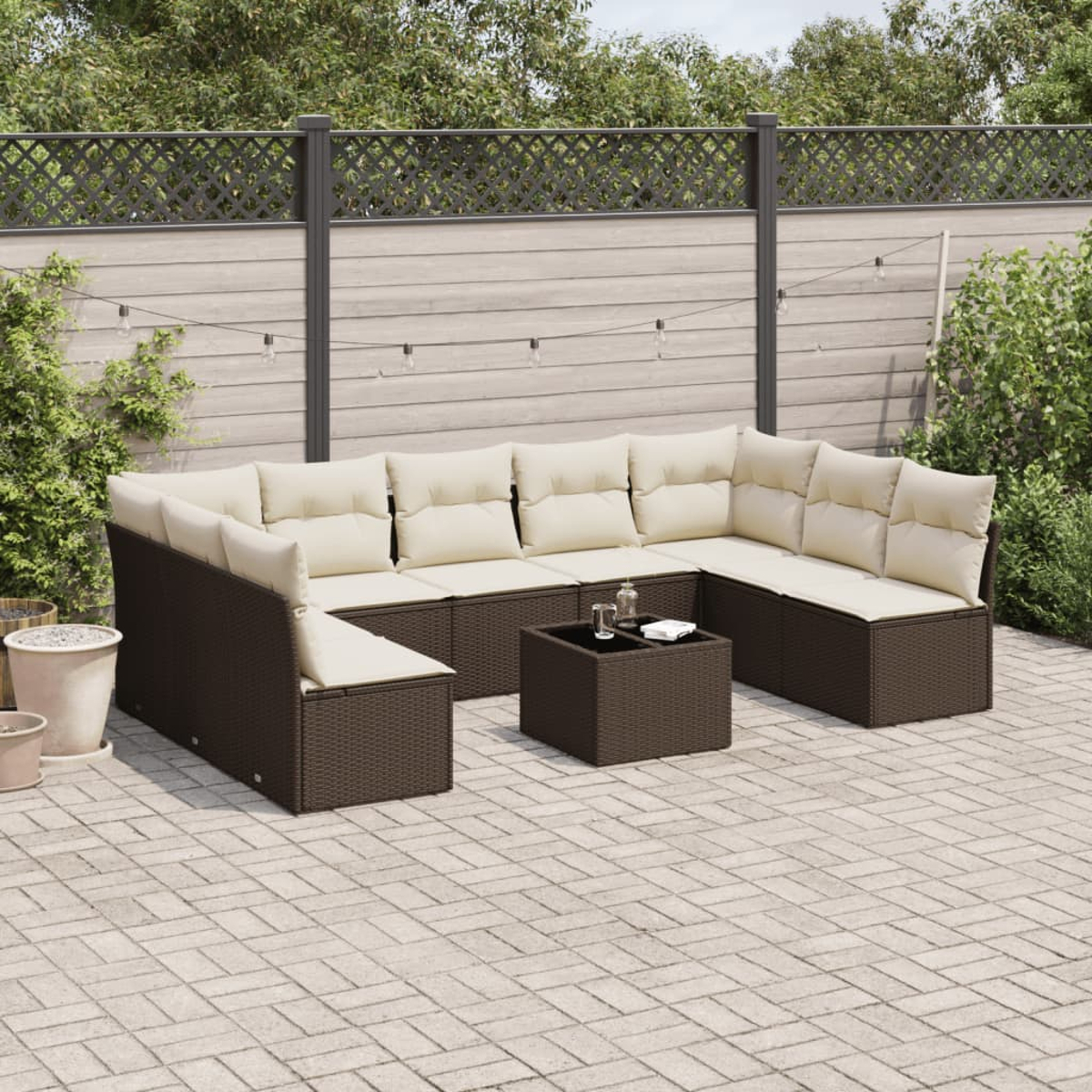Set da patio all'aperto con mobili in rattan marrone, cuscini beige e un tavolino.