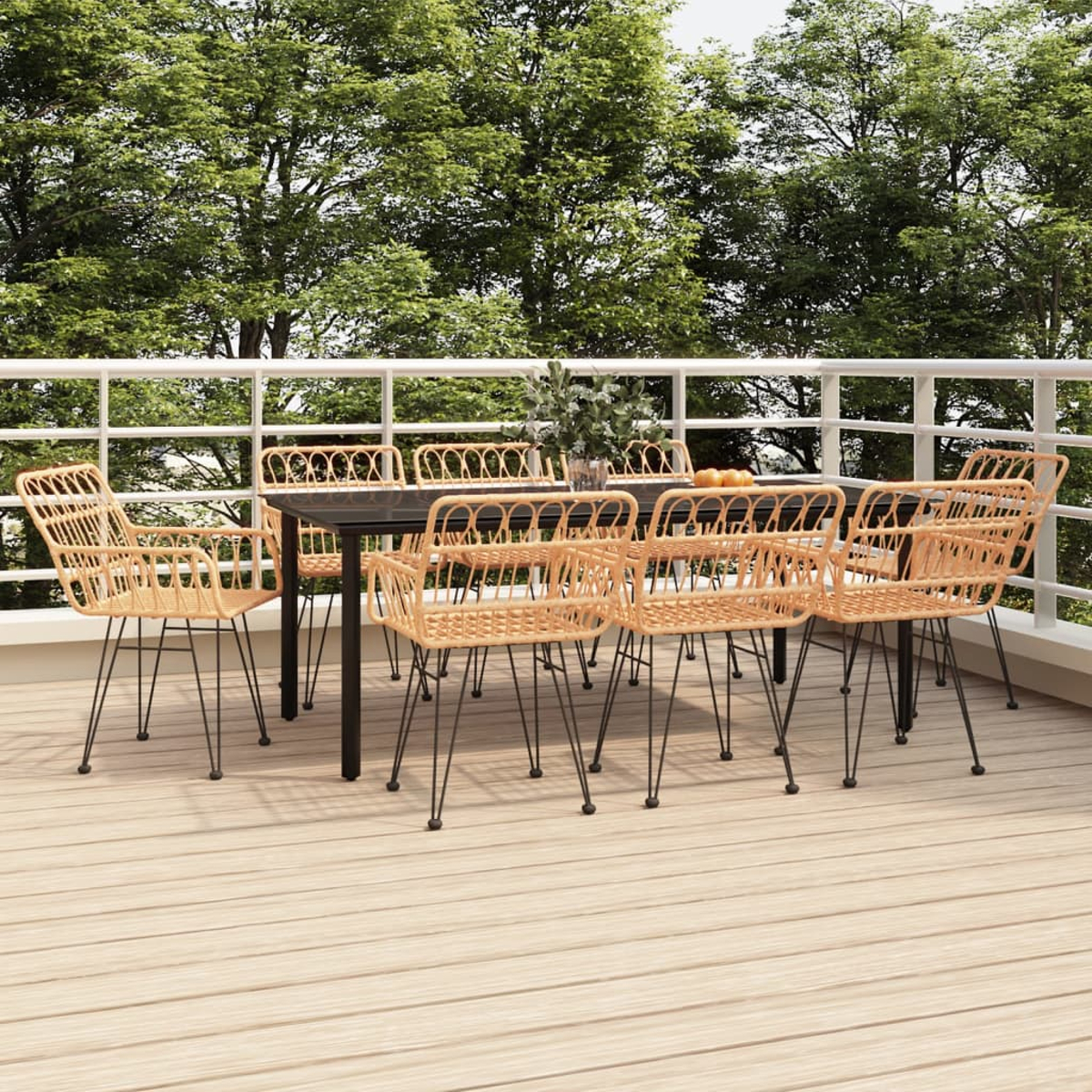 Essgruppe im Freien auf einer Terrasse. Rattan-Stühle und Tisch. Grüne Bäume im Hintergrund.