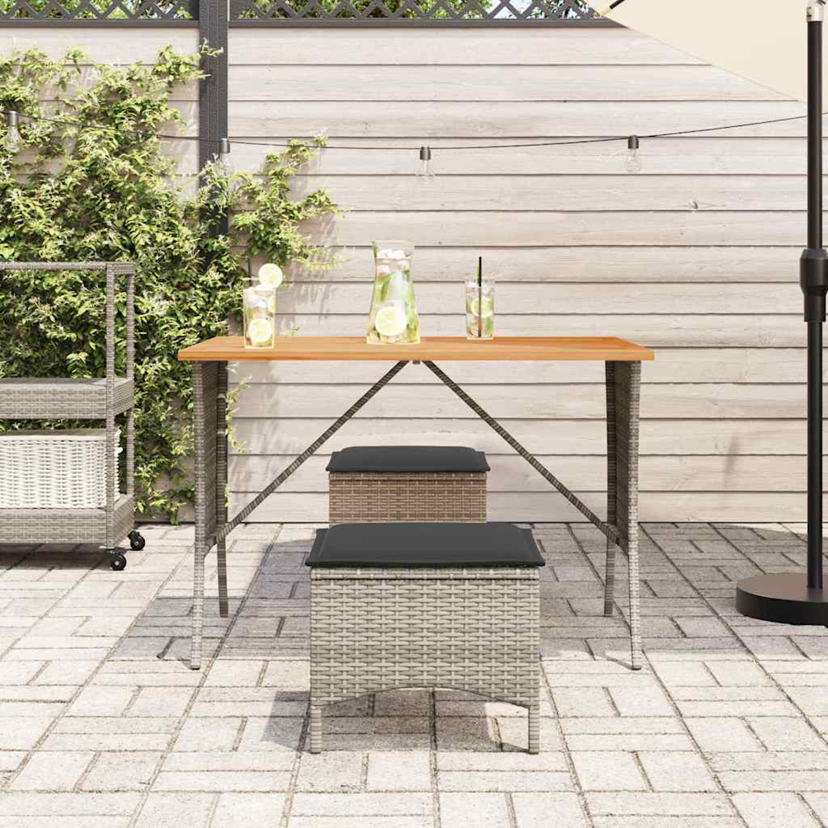 Tavolo da esterno con due sgabelli. Piano in legno, struttura in vimini grigio e bevande. Cortile.