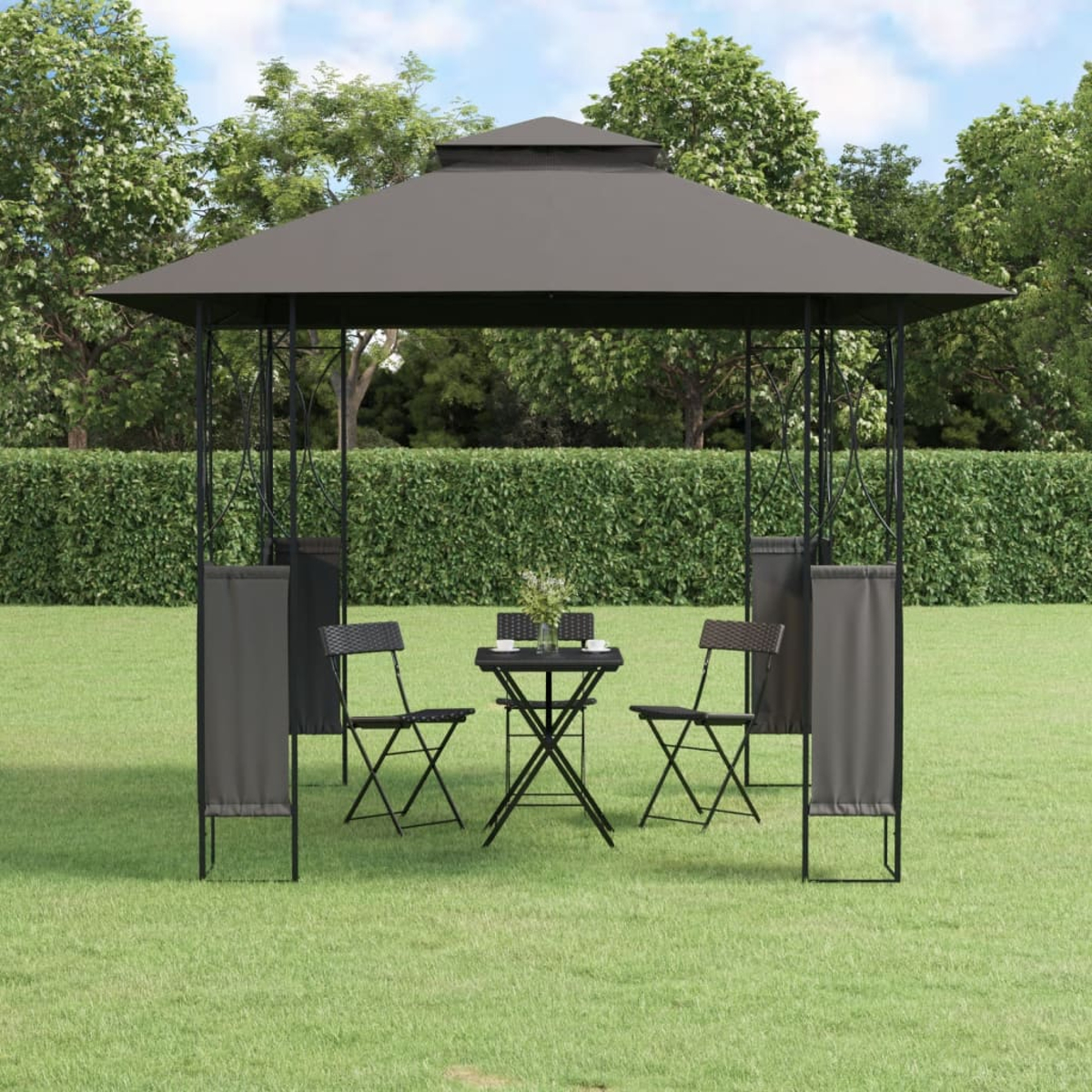 Ein Pavillon mit Tisch, Stühlen und Vorhängen auf Gras.