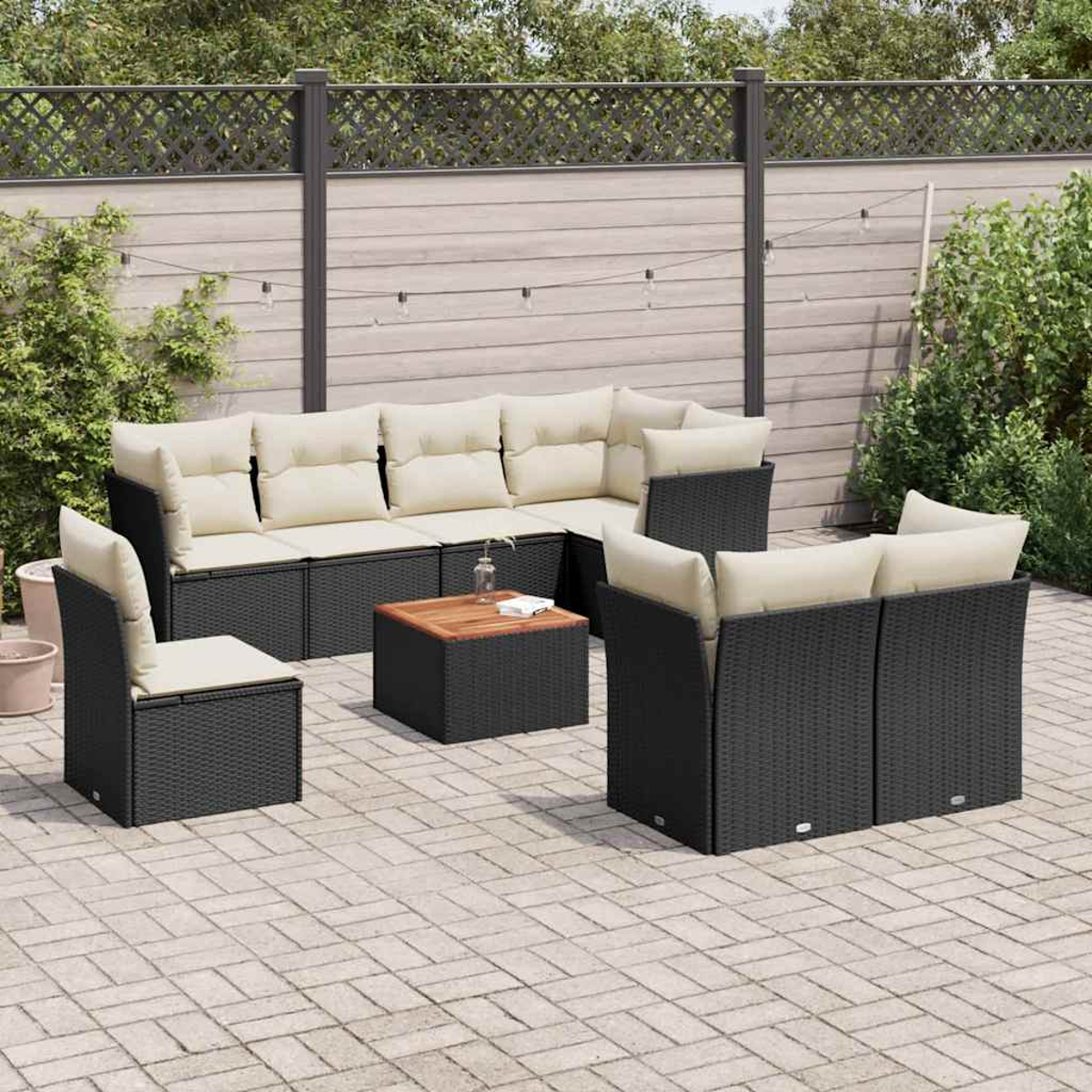 Terrassenmöbel-Set: Ecksofa, Stühle und Tisch. Schwarze Webmöbel mit beigen Kissen, auf einer Terrasse.