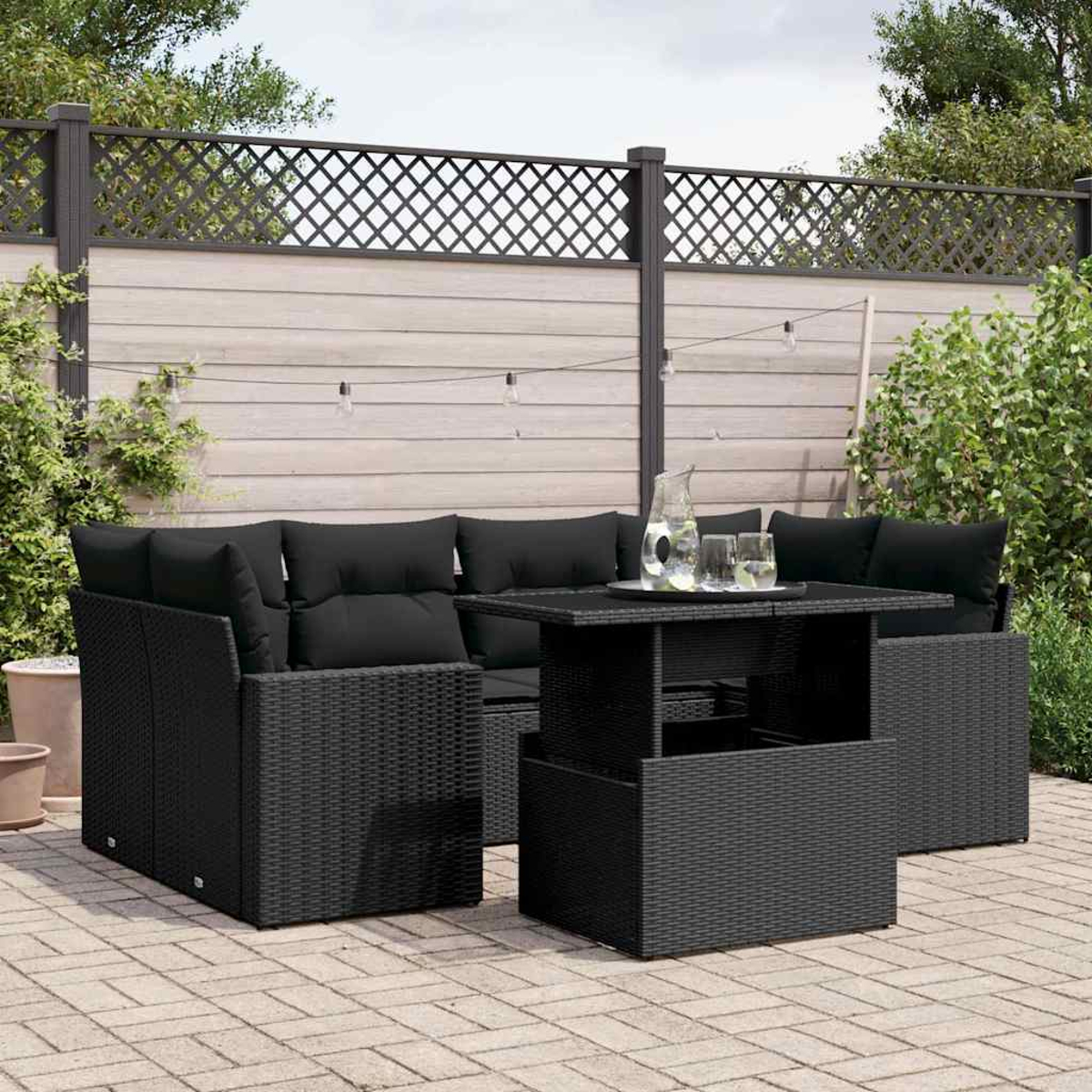 Schwarzes Korbmöbel-Set für die Terrasse mit schwarzen Kissen, einschließlich Tisch und Sofa.
